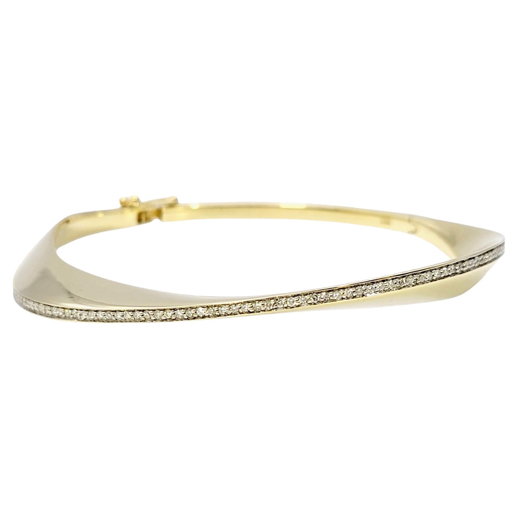 Uniquely designed contemporary bangle bracelet with sleek diamond wave design. This modern take on the classic bangle style will adorn your wrist with elegance and give a sophisticated, fashion-forward look that you will love.   

This beautiful