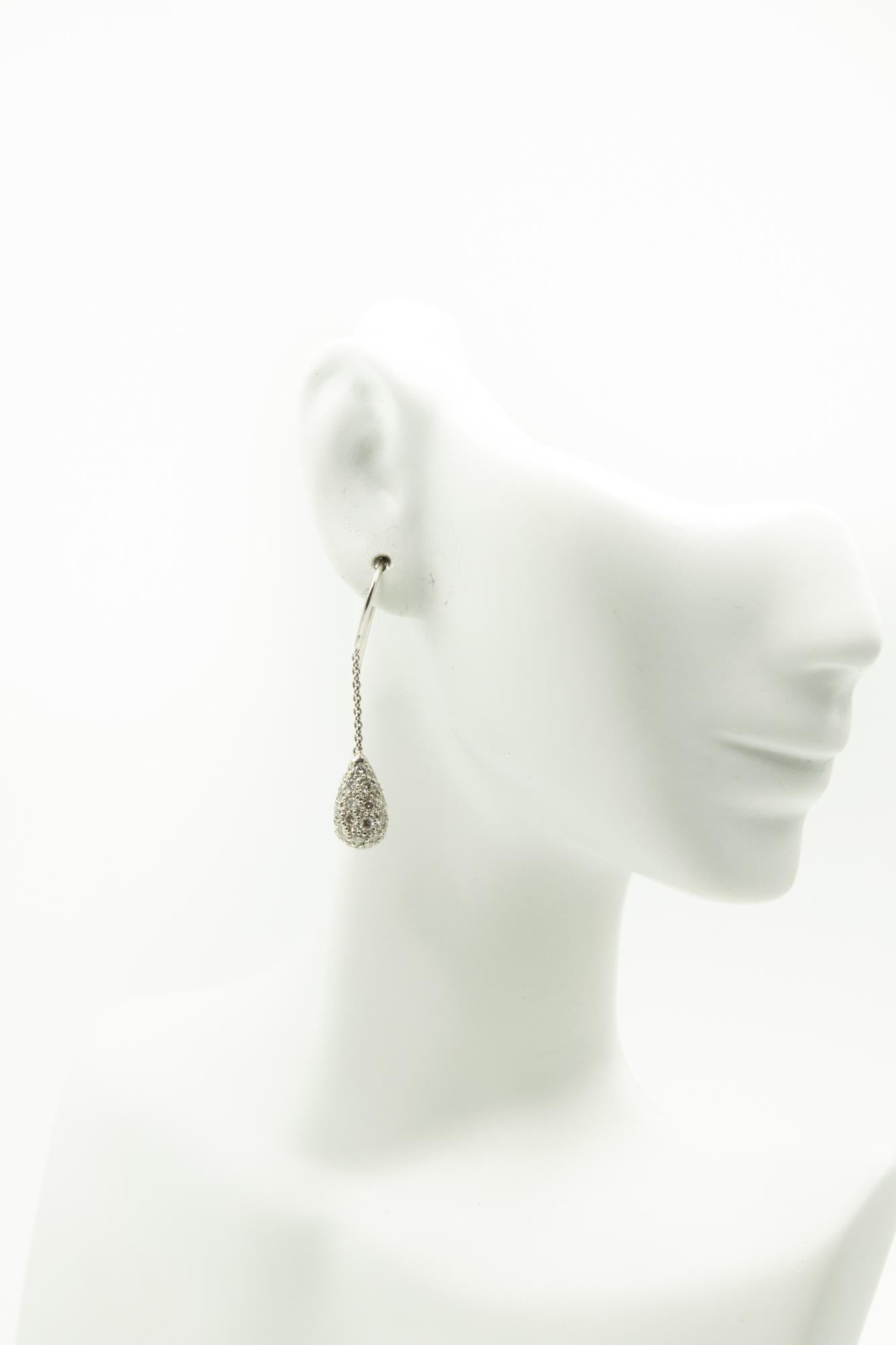 Pavé diamond teardrop earrings dangling on 18K white gold wire and chain. Hook backs for pierced ears. Diamond teardrops total an estimated 2.7 carats; clarity of the diamonds is SI.
