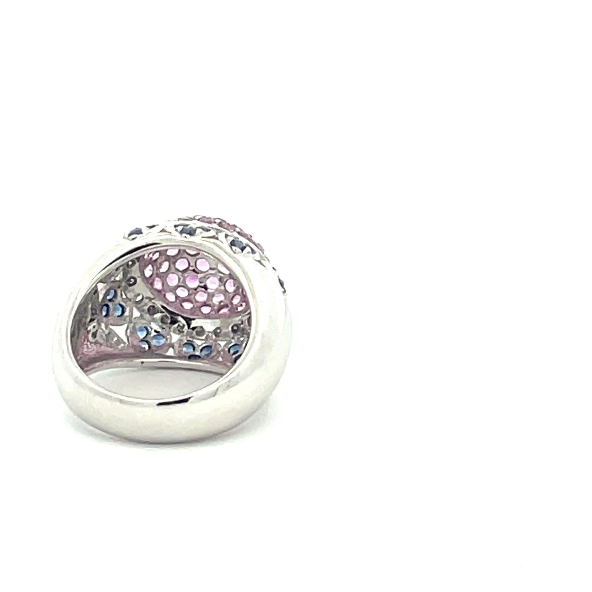 One dome ring set in centre with natural pink sapphires surrounded by a row of brilliant cut white diamonds and below that a row of heart motif set with natural blue sapphires  in 18kt white gold. 

56 natural pink sapphires 2.52ct total weight

30