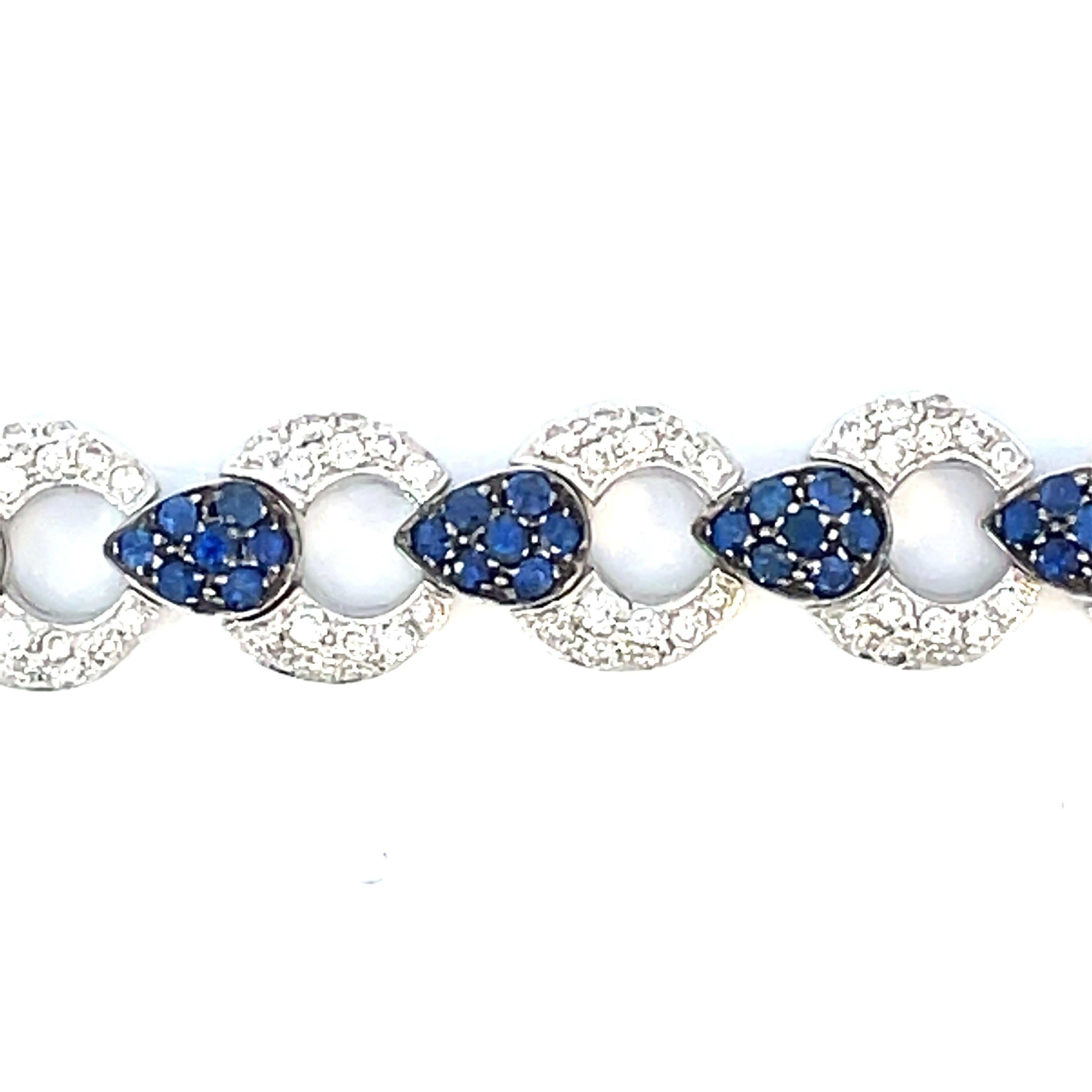 Ein elegantes Gliederarmband mit abwechselnd gepflasterten natürlichen weißen Diamanten und einem schwarzen Rhodium-Finish um die birnenförmigen Stationen aus natürlichem blauem Saphir in 18-karätigem Weißgold.

112 natürliche blaue Saphire mit