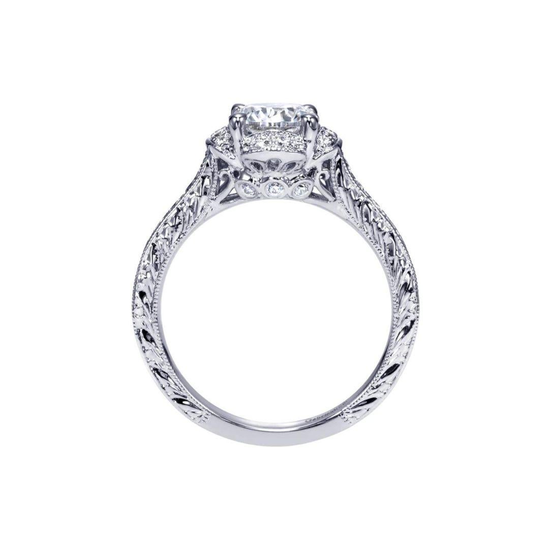 Ladies' Petals 14k White Gold Diamond Engagement Mounting. Pave set diamonds in a faux channel setting offset the rich diamond etchings on the sides of the ring. The halo is in the shape of stylized petals for a modern spin on a floral theme. Center