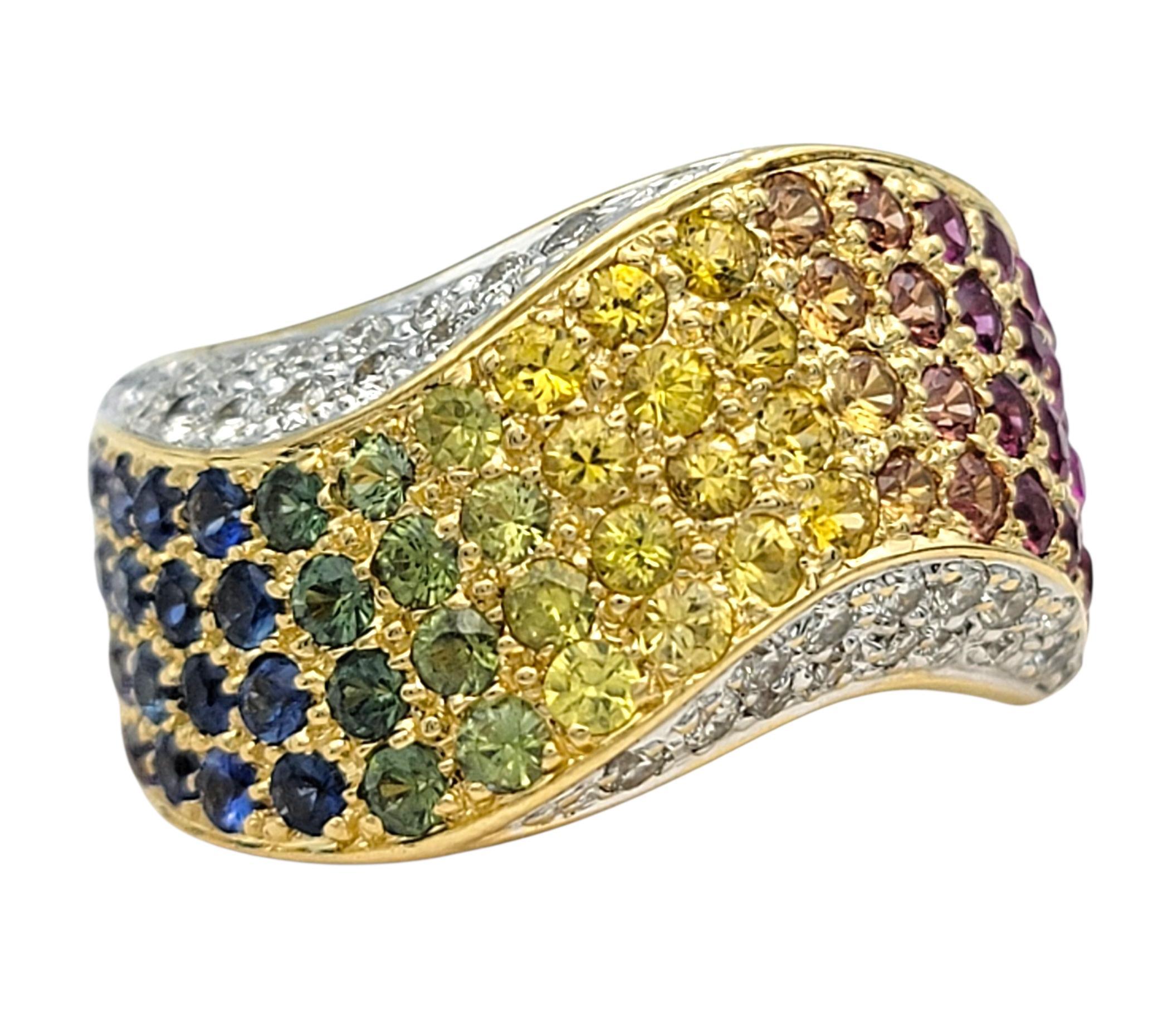 Questo vibrante anello con zaffiro e diamante mostra uno spettro di colori mozzafiato, mescolando toni caldi e freddi in perfetta armonia. Da blu e viola profondi a gialli, arancioni e rosa brillanti, le gemme sono disposte in un gradiente senza