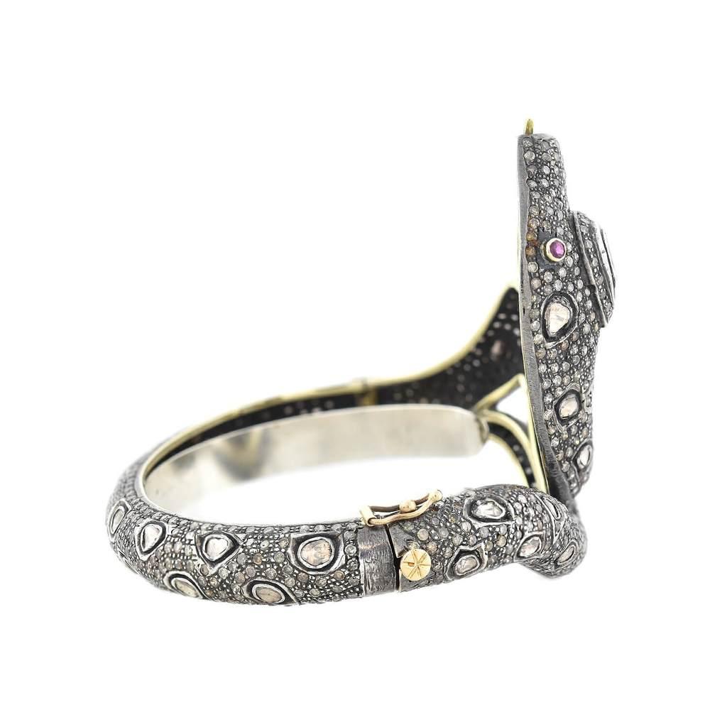 Crafted in 14kt yellow gold and sterling silver, this intriguing bracelet is encrusted with glittering diamonds. With a total approximate weight of 3ctw, this bracelet is absolutely gorgeous! Single Cut diamonds adorn the body while larger Rose Cut