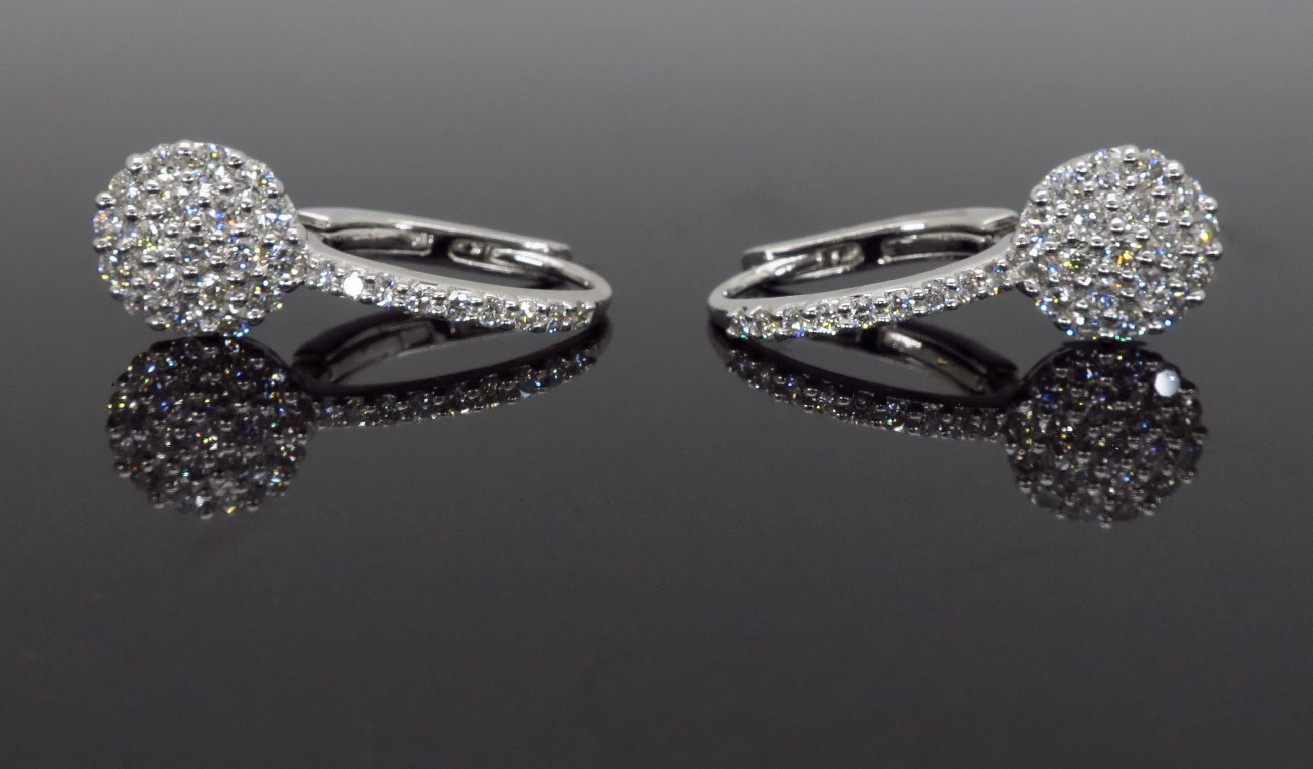 Circular cluster diamond drop earrings crafted in 18k white gold. 

Diamond Carat Weight: Approximately .78CTW 
Diamond Cut: Round Brilliant Cut 
Color: Average G-H
Clarity: Average VS
Metal: 18K White Gold
Marked/Tested: Stamped “750 18K