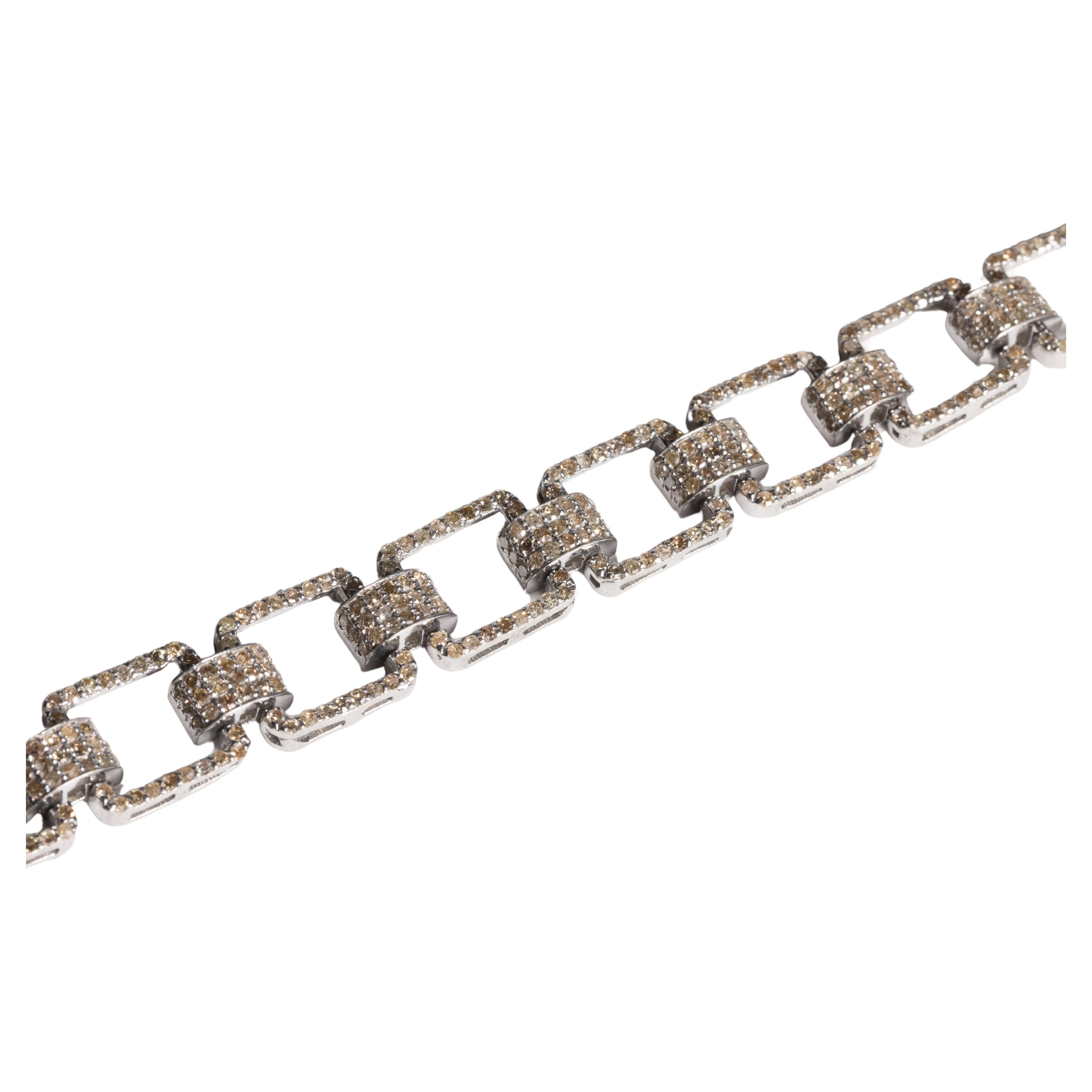 A handsome box chain bracelet in an oxidized sterling silver.  The entire bracelet is set with round, brilliant cut diamonds in a pave` setting.  The diamonds total 5.46 carats.  Has a hinged snap lock clasp.

The fine jewelry collection is sourced,