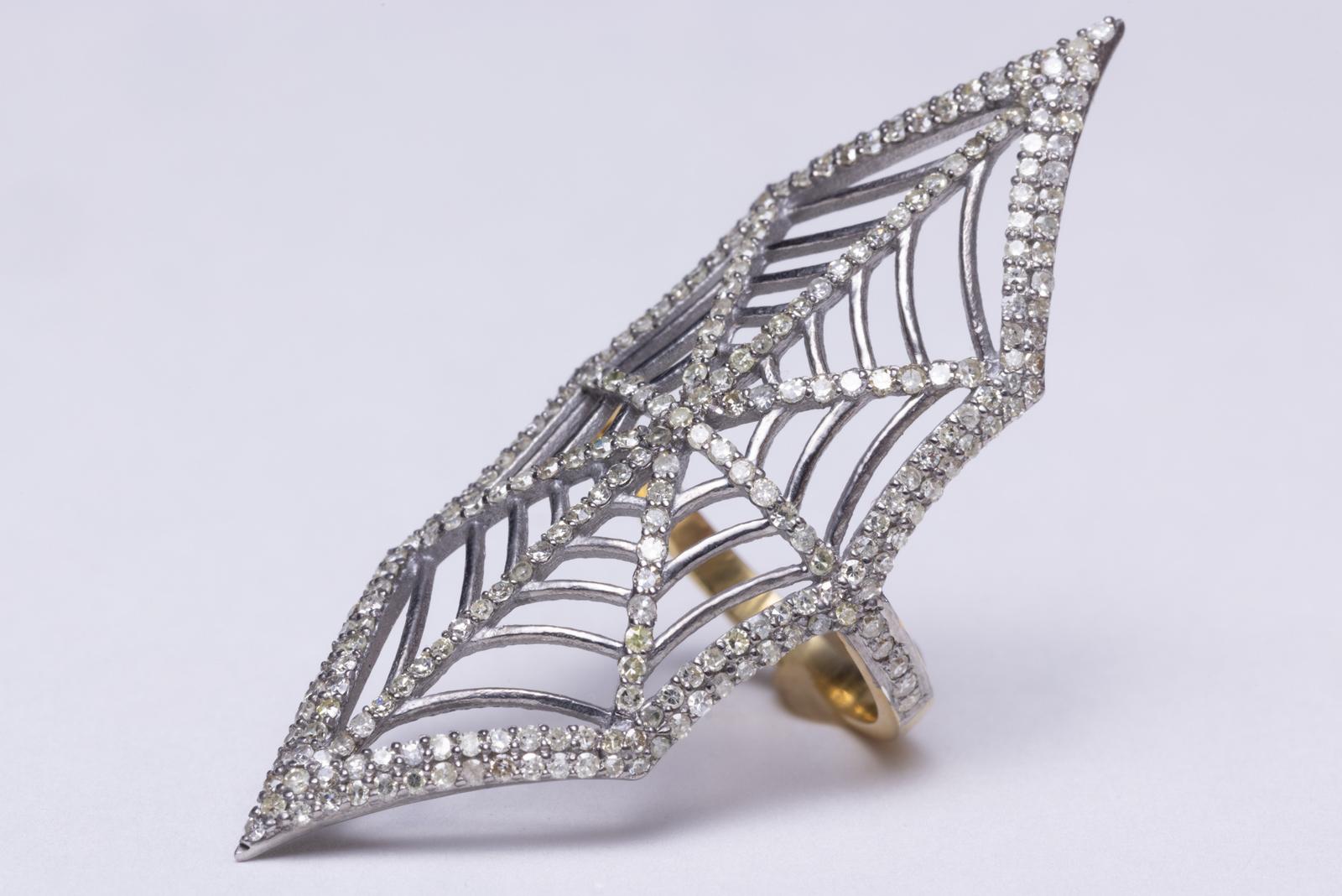 A very cool ring of round, brilliant cut diamonds in a pave` setting mounted in sterling silver in a spider web design.  Actually quite comfortable for its size.  Carat weight of diamonds total 1.6 carats.   Ring size is a 7.