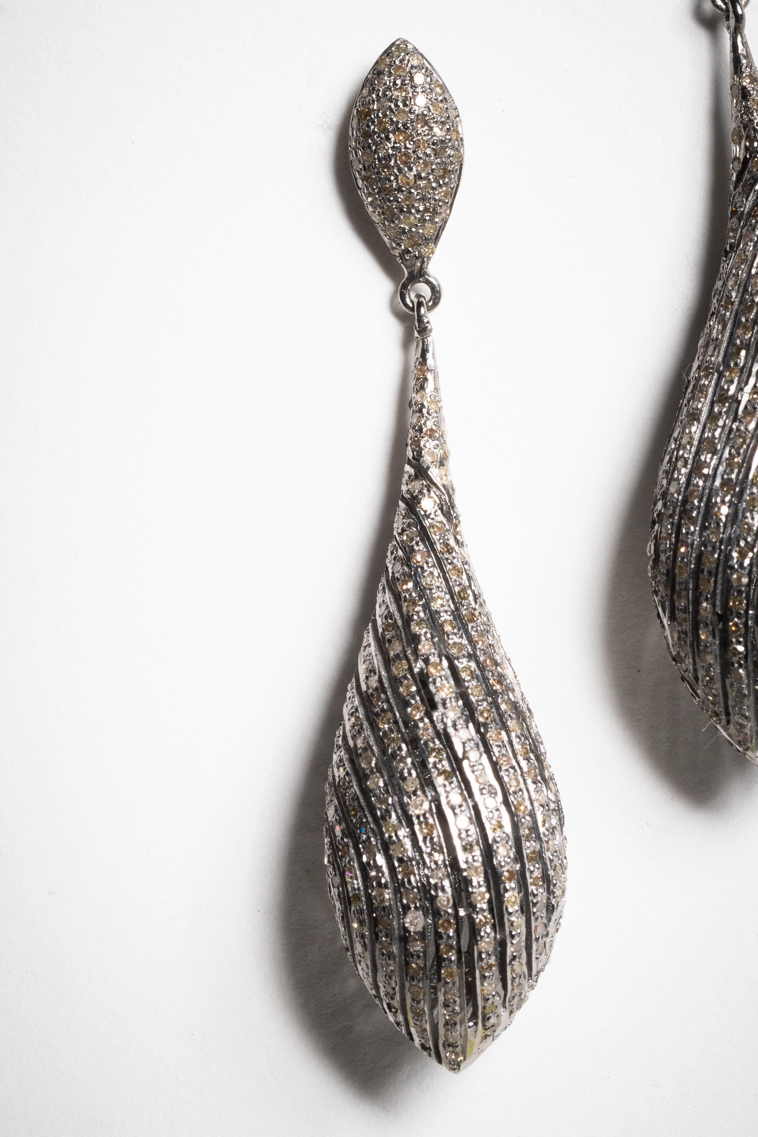 Boucle d'oreille pendante en forme de goutte d'eau, entièrement sertie de diamants ronds de taille brillant en pavage.  Serti en argent sterling avec une tige en or 18 carats pour les oreilles percées.  Les diamants totalisent 4,10 carats.

La