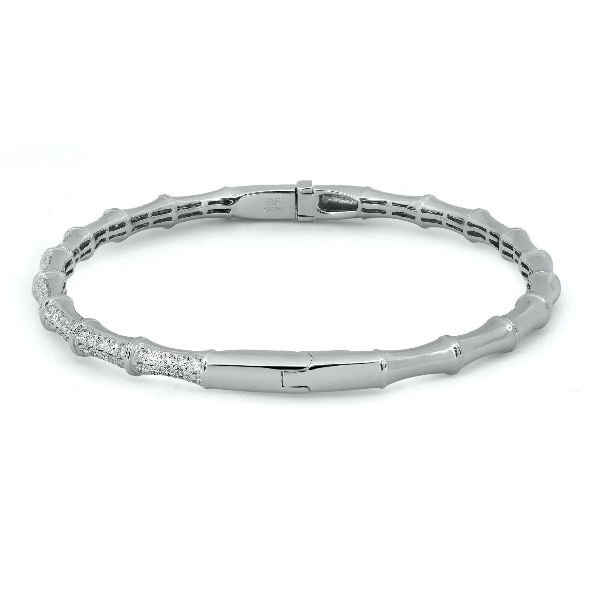 A classic look with easy elegance, this diamond bangle bracelet exudes sophistication. Features pave set round brilliant cut diamonds weighing 0.94 carats studded halfway through the bangle. Crafted in high polished 18K white gold. Diamond color G-H