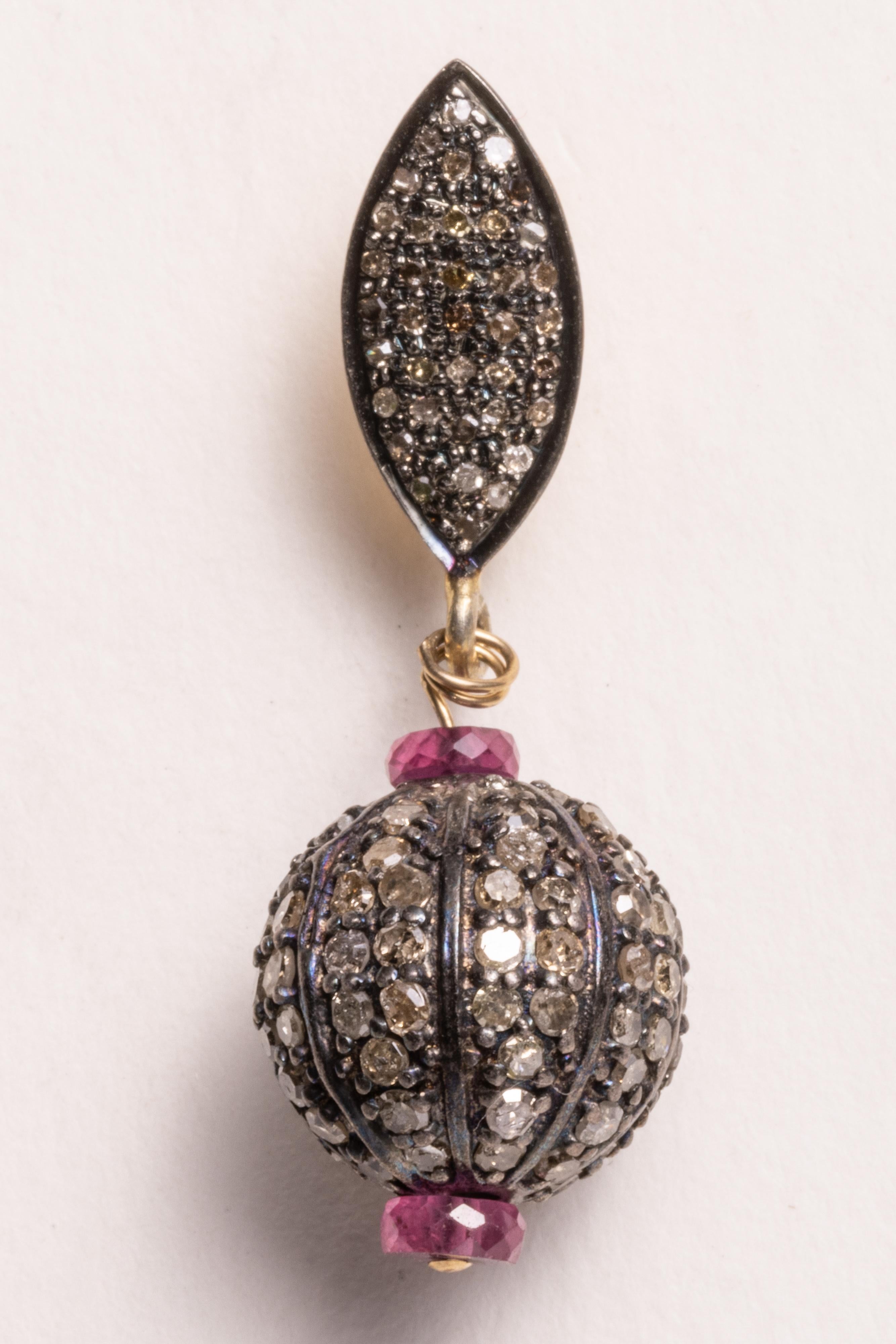 Pave`-set diamond balls and earring posts with round, brilliant cut diamonds with faceted pink rubies.  Set in sterling silver with 18K gold posts for pierced ears.

The fine jewelry collection is sourced, designed or created by Deborah Lockhart