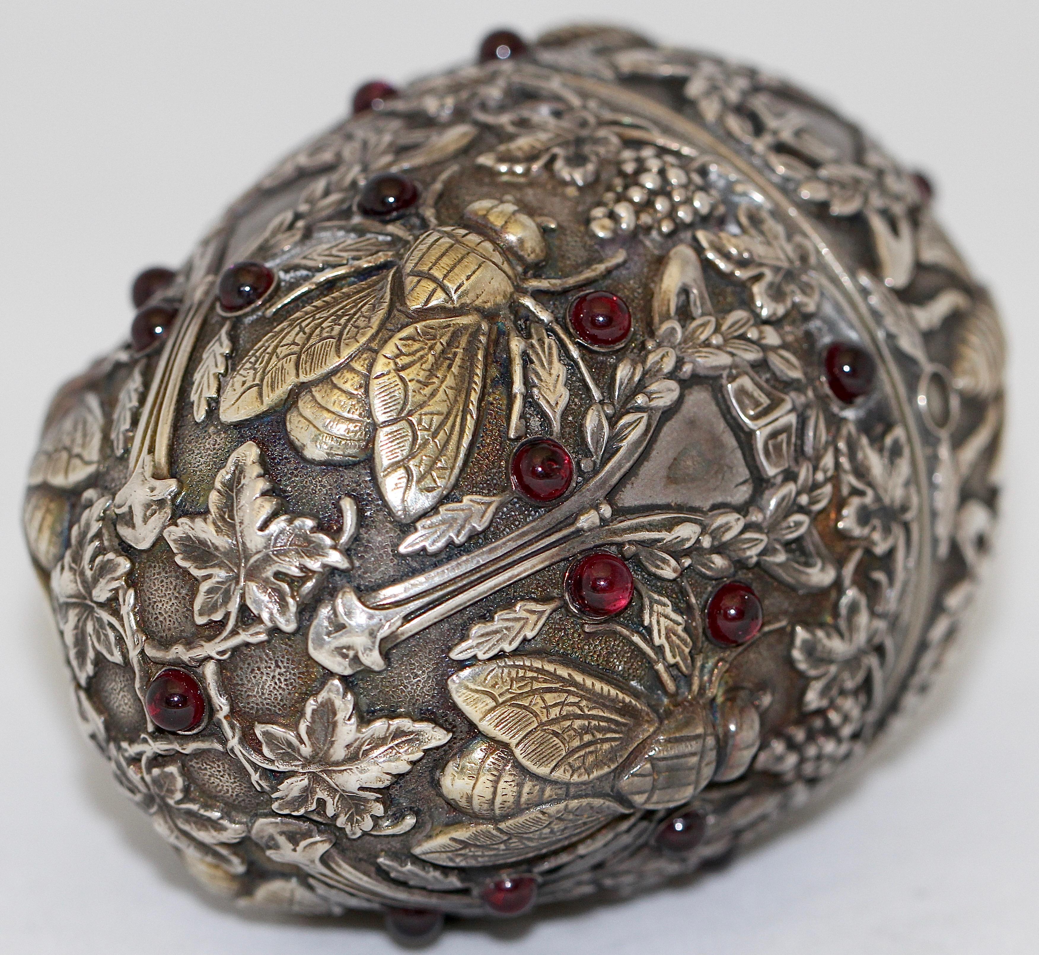 Pavel Ovchinnikov. Russian Faberge Style 84 silver insects Egg. With Garnets.

This magnificent Russian silver egg adorned with cabochon garnets throughout has a raised design depicting flies, bees, leaves and grape clusters.  Gold wash to interior.