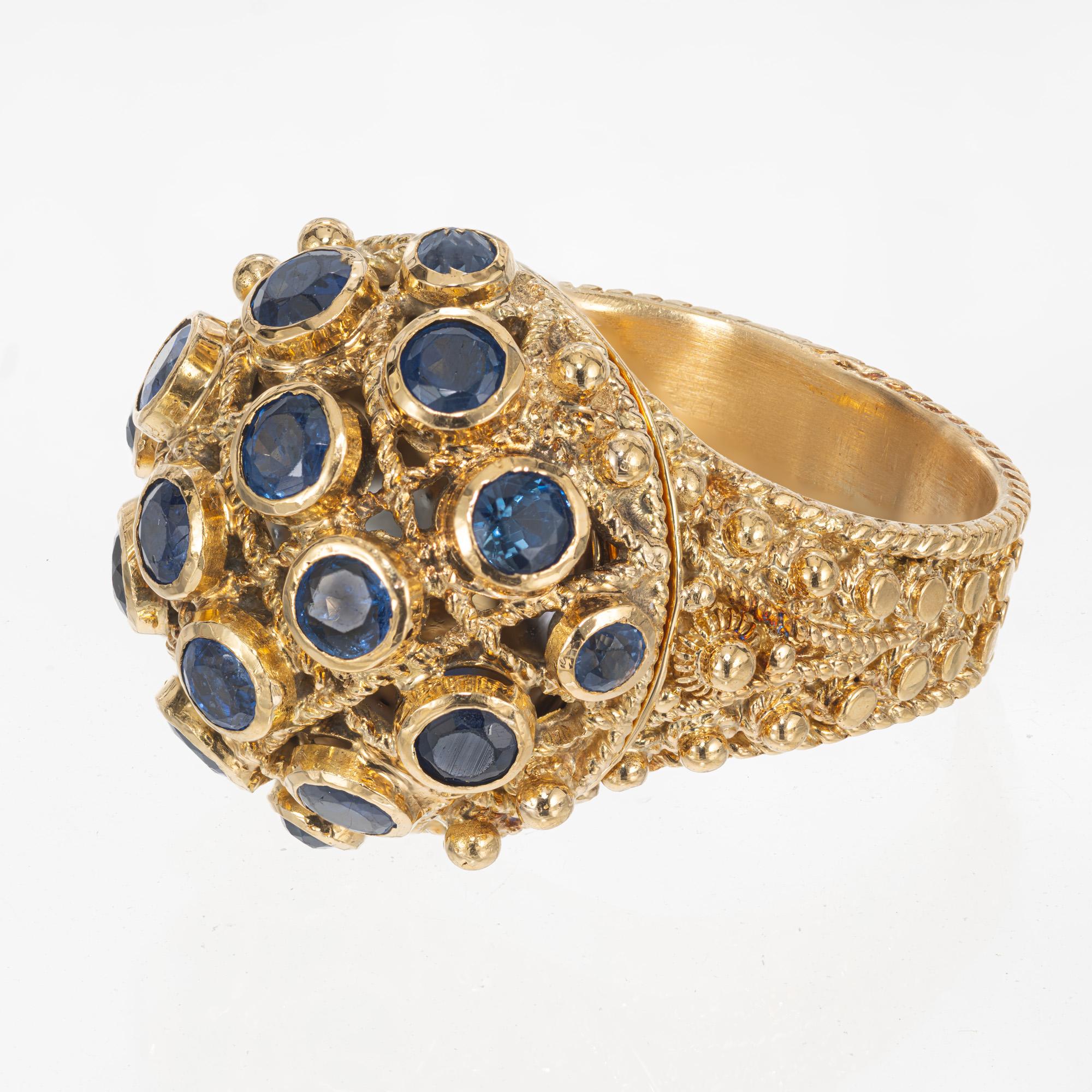 Sapphire Poison handmade cocktail ring. These unique ring is adorned with 16 round bezel set sapphires, mounted on a dome style top. Twisted 19k yellow gold wire sperate each stone. The hinged dome top lifts up. Granulation work is detailed