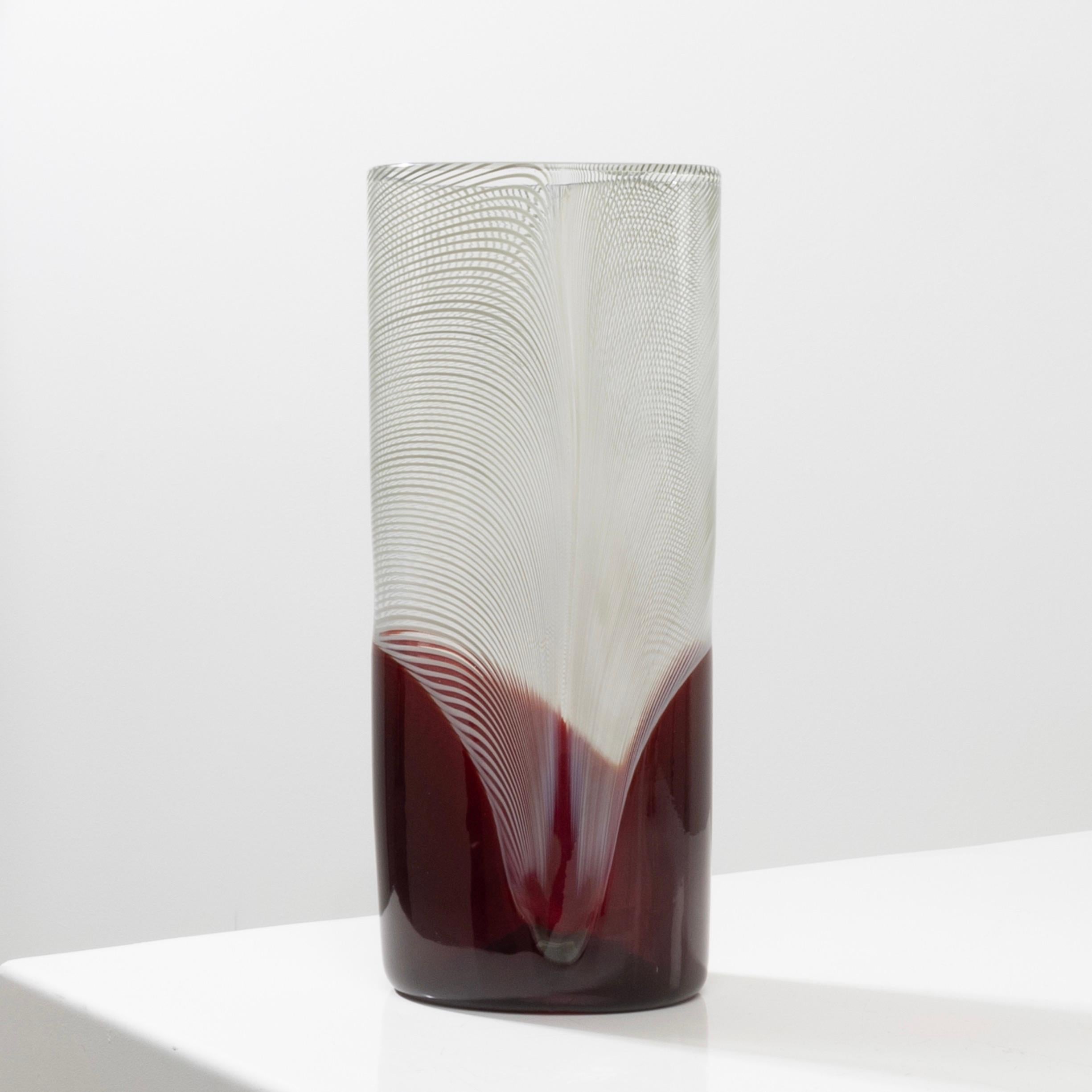 Pavoni by Tapio Wirkkala – High blown Murano glass vase
Pavoni by Tapio Wirkkala, high blown Murano glass vase.
Vase with an oval cross section.
Decor in filigrana over red glass.
A vase from the latest series designed by the artist for Venini