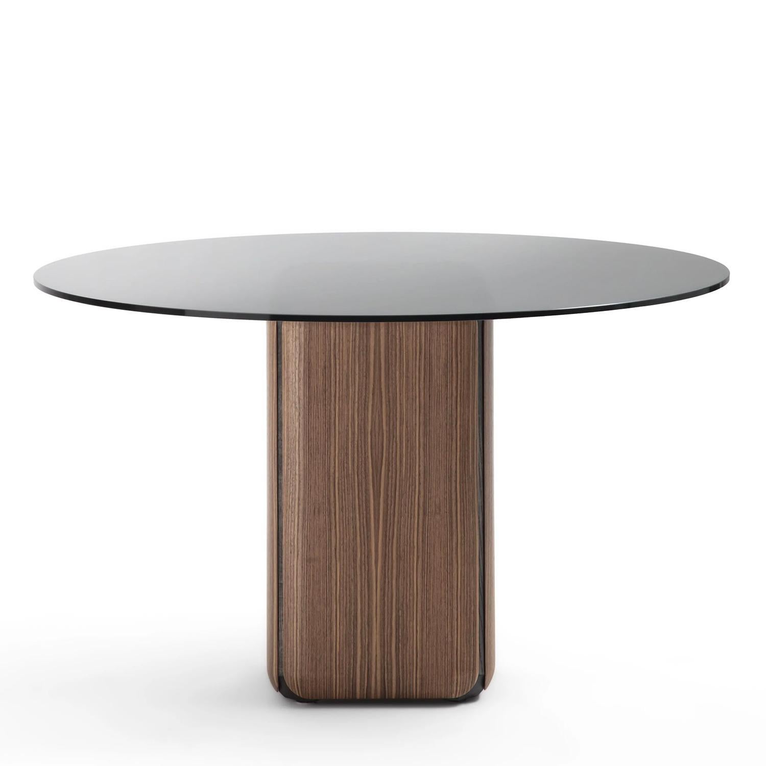 Table Pax Glass Round avec plateau en verre smocké, base avec plateau en verre smocké.
parties extérieures amovibles en noyer massif avec cadre intérieur en acier inoxydable.
frêne massif en finition teintée grise. Base avec pieds d'extrémité