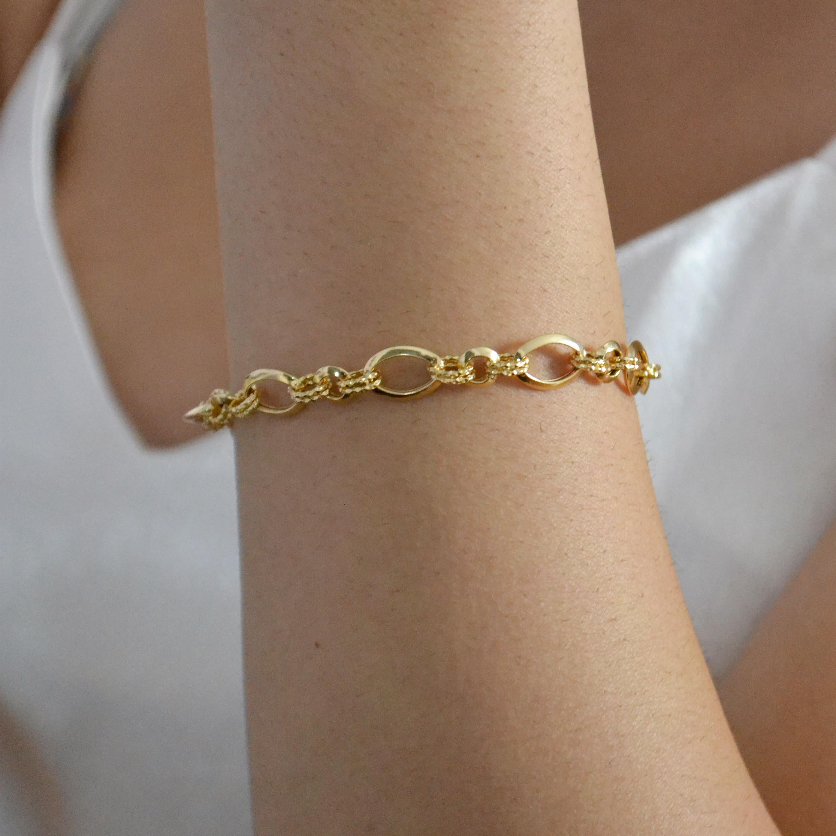Esta pulsera de oro amarillo de 18 quilates aporta un toque atrevido y elegante a tu guardarropa de joyas, con una sorprendente combinación de eslabones ovales lisos y conectores estilo cuerda de textura compleja. El dibujo alternado crea