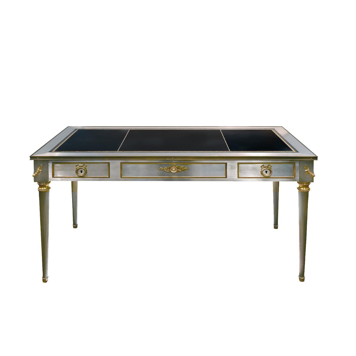Hand-crafted desk in brushed stainless steel with intricate brass pulls and accents with 3 drawers and embossed black leather top by P.E. Guerin, American c.1950 (signed “P.E.G.” on back of pull). It has been authenticated by the workshop. 
 This