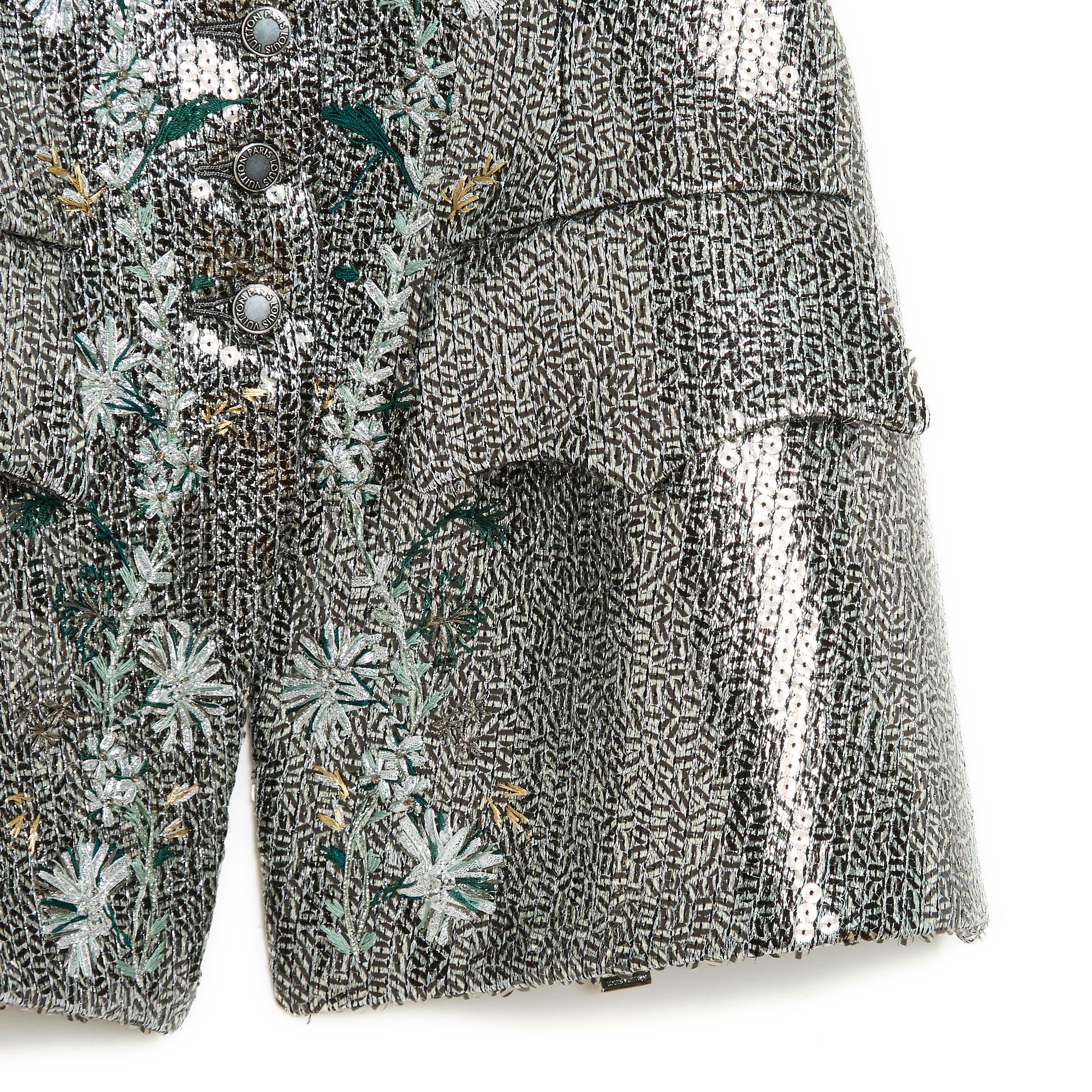 Chaqueta Louis Vuitton colección SS2018 de Nicolas Ghesquière sin mangas de hilo de seda de color plateado totalmente bordada con lentejuelas a rayas negras translúcidas y un motivo floral en la parte delantera, escote en V cerrado con 7 botones con