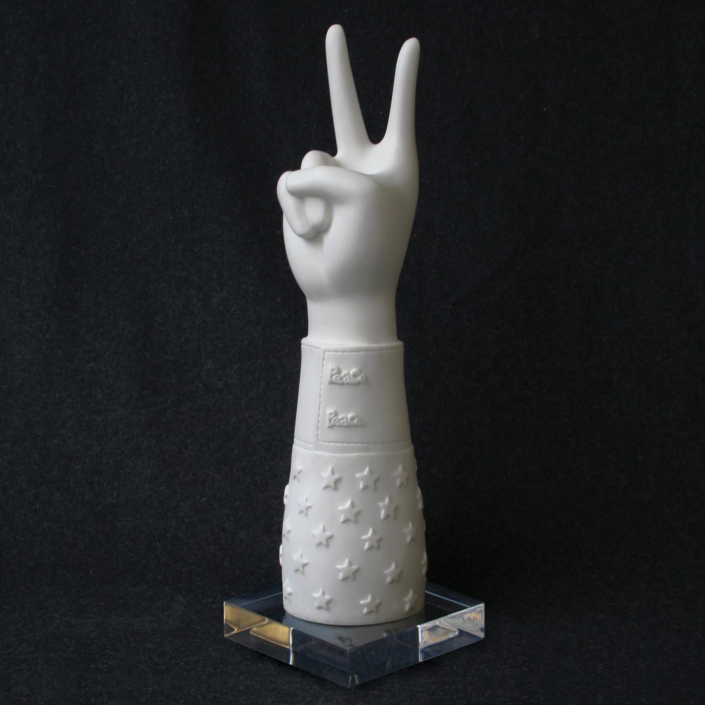 Talk to the hand. Our statement sculptures are made from high-fired matte porcelain, then poised atop a chic acrylic platform. From your tabletop, mantel or shelf, they're the perfect way to let guests know what you stand for—peace, love,