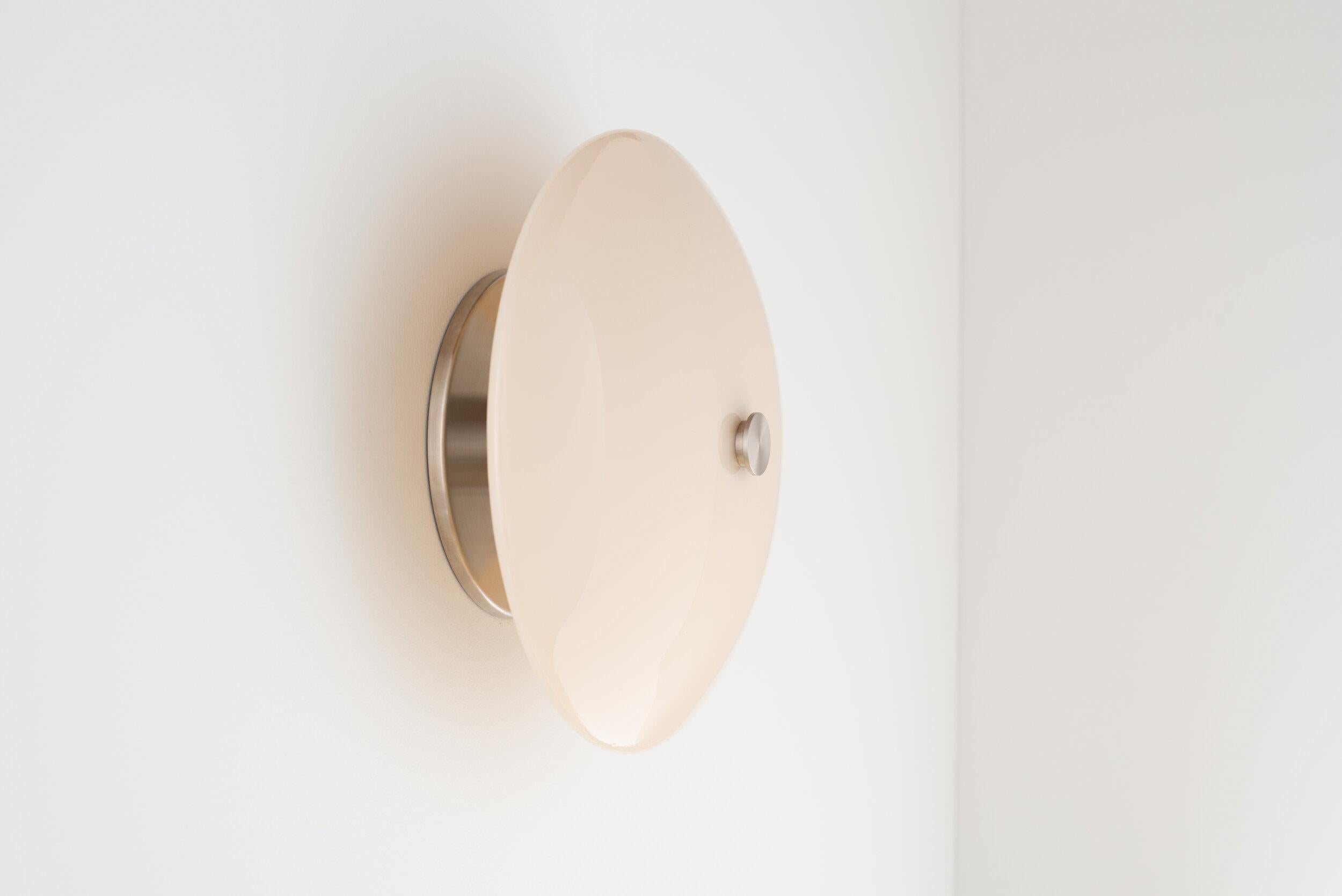 A modern dome of hand poured and slumped glass floats effortlessly off the wall providing distinct dimmable illumination. 

The Lyra sconce is available in multiple glass colors and illuminated by a 120V AC direct drive led module with no external