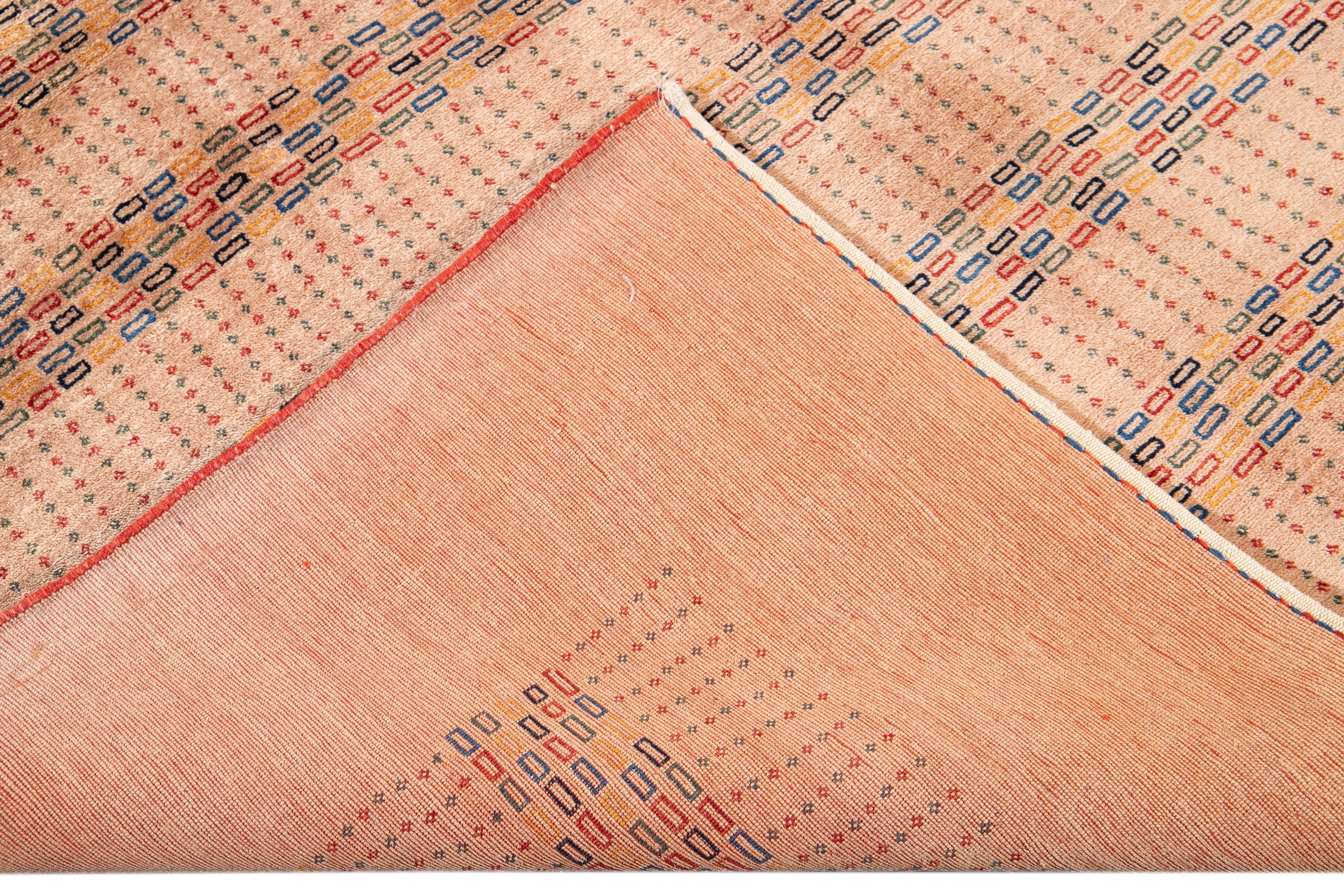 Schöne zeitgenössische persische Gabbeh handgeknüpfte Wolle mit Pfirsich Feld Teppich. Dieser Gabbeh-Teppich hat rote, blaue, gelbe und grüne Akzente in einem prächtigen geometrischen Muster.

Dieser Teppich misst: 5'10