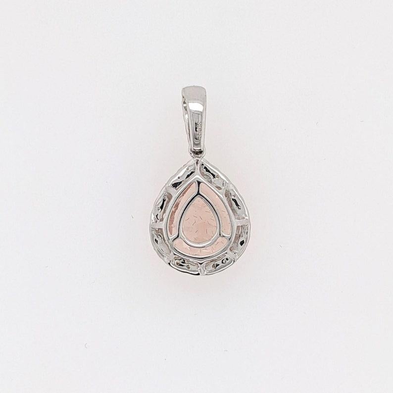 Specifications:

Item Type: Pendant
Gold Purity: 14k
Gold weight: 1.51 grams
Diamond: 29 diamonds totaling 0.36 cts

Stone Specs:
Type: Peach Morganite
Weight: 0.66 cts
Shape: Pear Shape
Size: 11x9mm
Treatment: Heated
Hardness: 7.5-8

This pendant