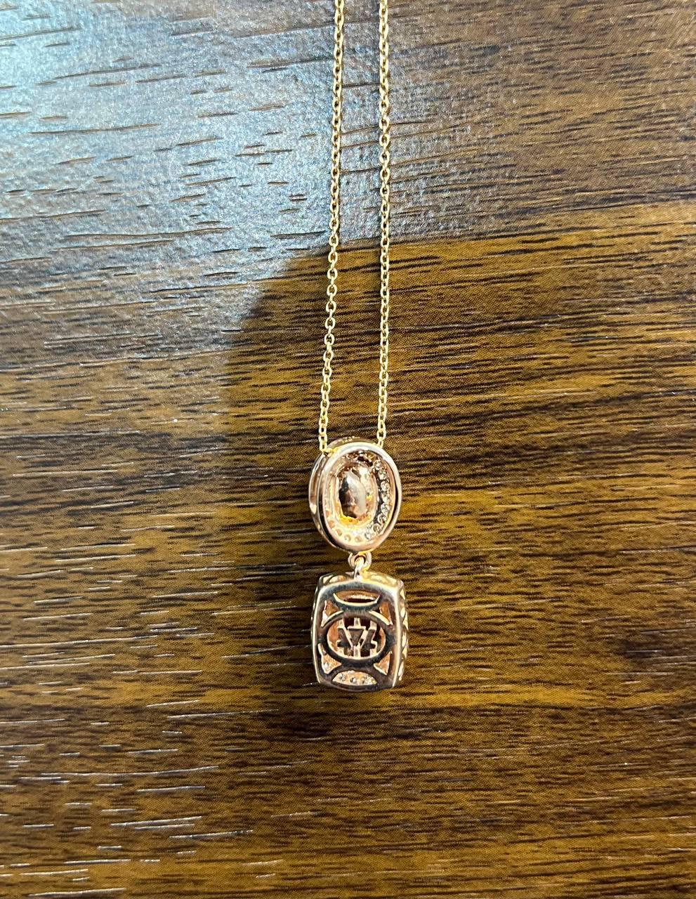 This exquisite necklace features a dual-stone design, with a oval opal and a rectangular peach morganite, each encircled by delicate accent diamonds.

Crafted with precision, the pendant hangs gracefully from a fine chain, highlighting the stones'