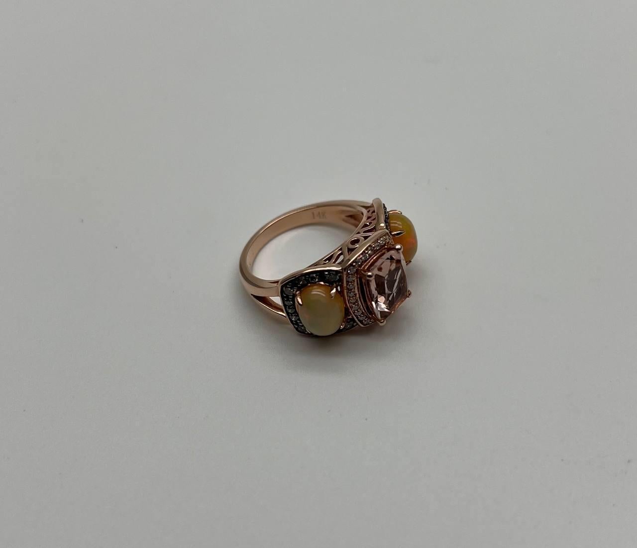Elegant Three-Stone Ring with Opal and Morganite stones. This exquisite ring features a central rectangular morganite, flanked by two opals on either side. The setting is intricately detailed with small, sparkling diamonds surrounding the main gem,