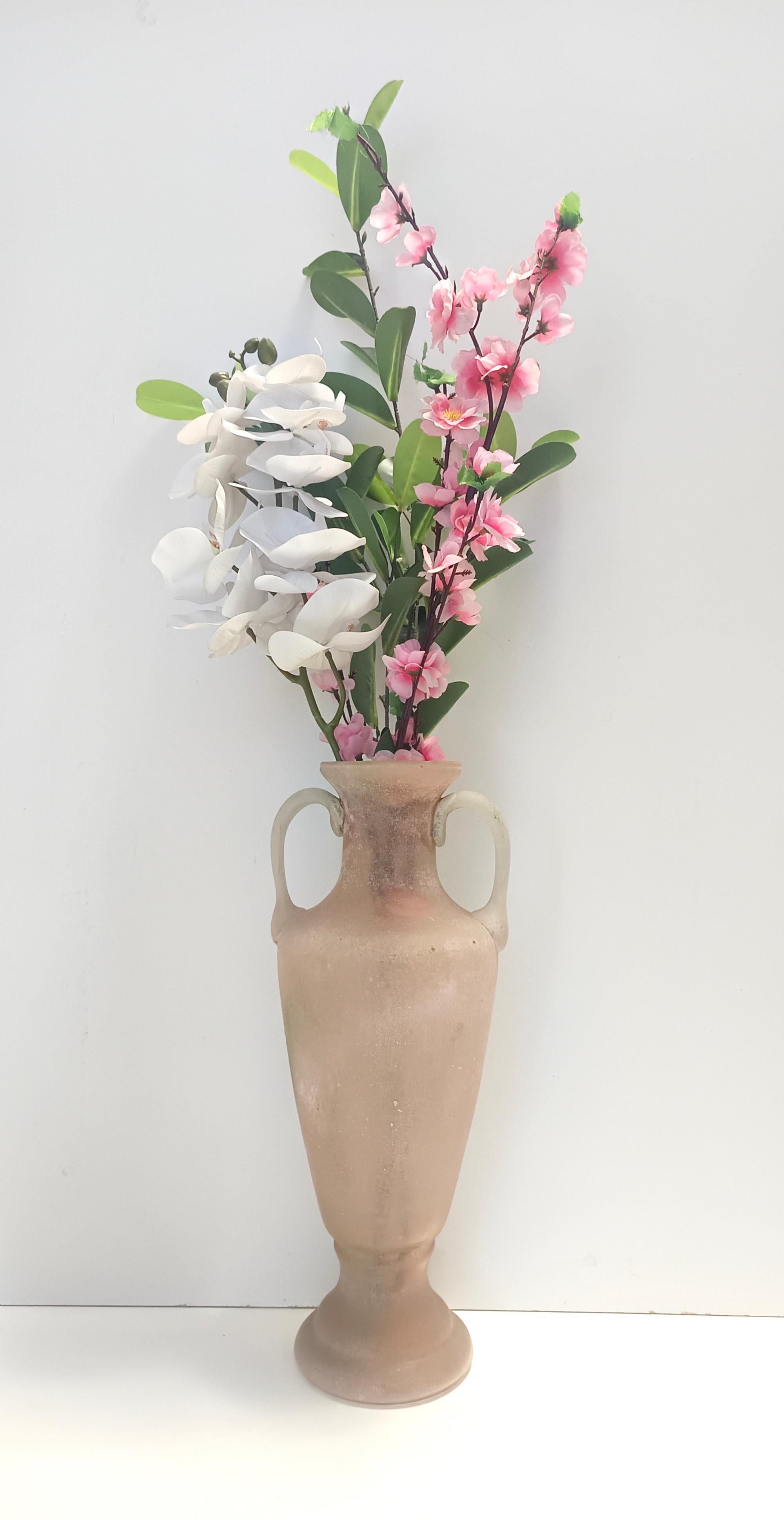 Made in Italy, anni '60. 
Questo vaso è realizzato in vetro di Murano soffiato a bocca di colore rosa pesca e bianco scavo ed è attribuibile a Seguso, un'importante azienda vetraria fondata nel 1397.
Seguso è famosa per i suoi disegni