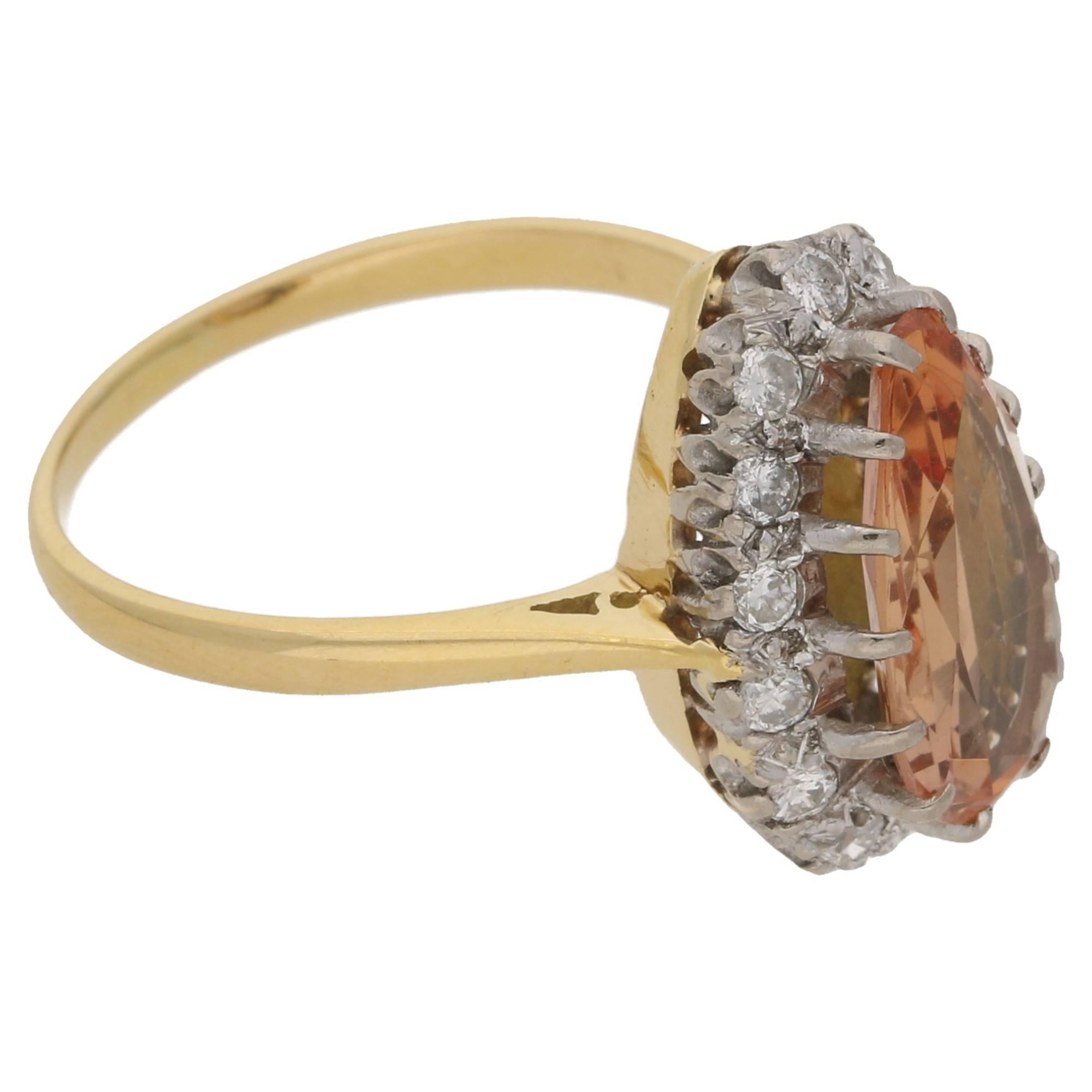 A pendeloque cut peach coloured topaz set in fourteen platinum claws, surrounded by a border of fourteen round brilliant cut diamonds, claw set in platinum. Leading to an 18ct yellow gold undercarriage with open cheniers. Estimated topaz weight