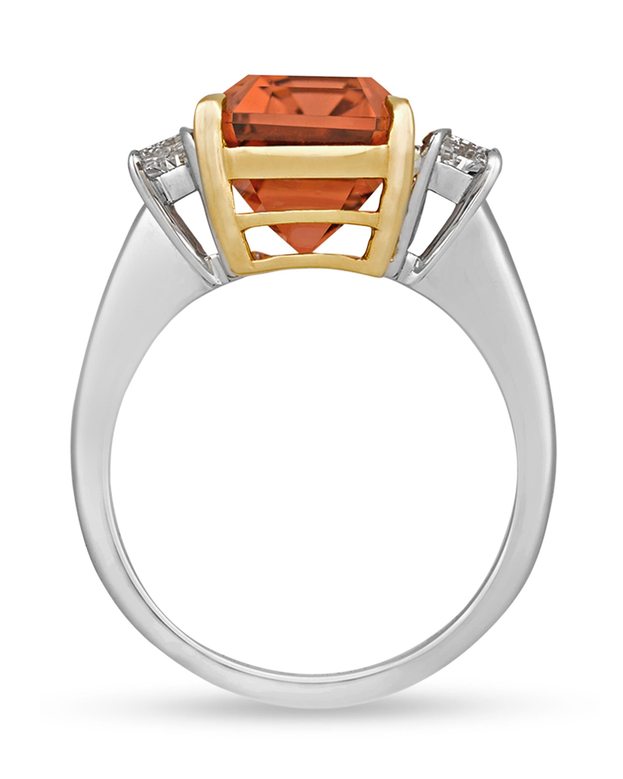 A highly unique peach tourmaline is set in this impressive ring. Displaying a distinctive orange-pink hue, the octagonal-cut gemstone features an elongated cut that makes the most of its 10.79-carat weight. The tourmaline is flanked on each side by