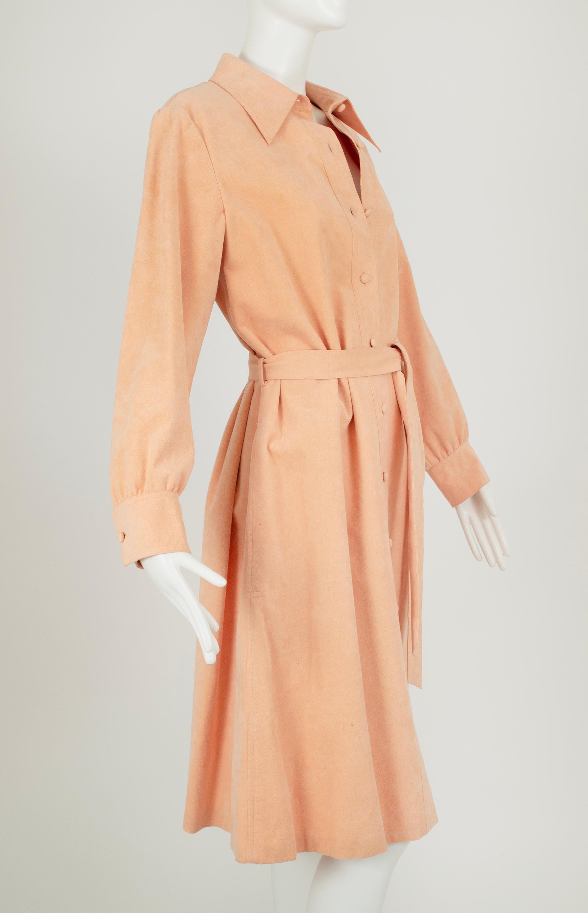 Resi famosi da Halston, gli abiti in Ultrasuede sono stati pensati per le donne lavoratrici appena liberate che avevano bisogno di abiti pratici e professionali ma dall'aspetto chic. Questo abito, di un colore neutro e pastello che attraversa le
