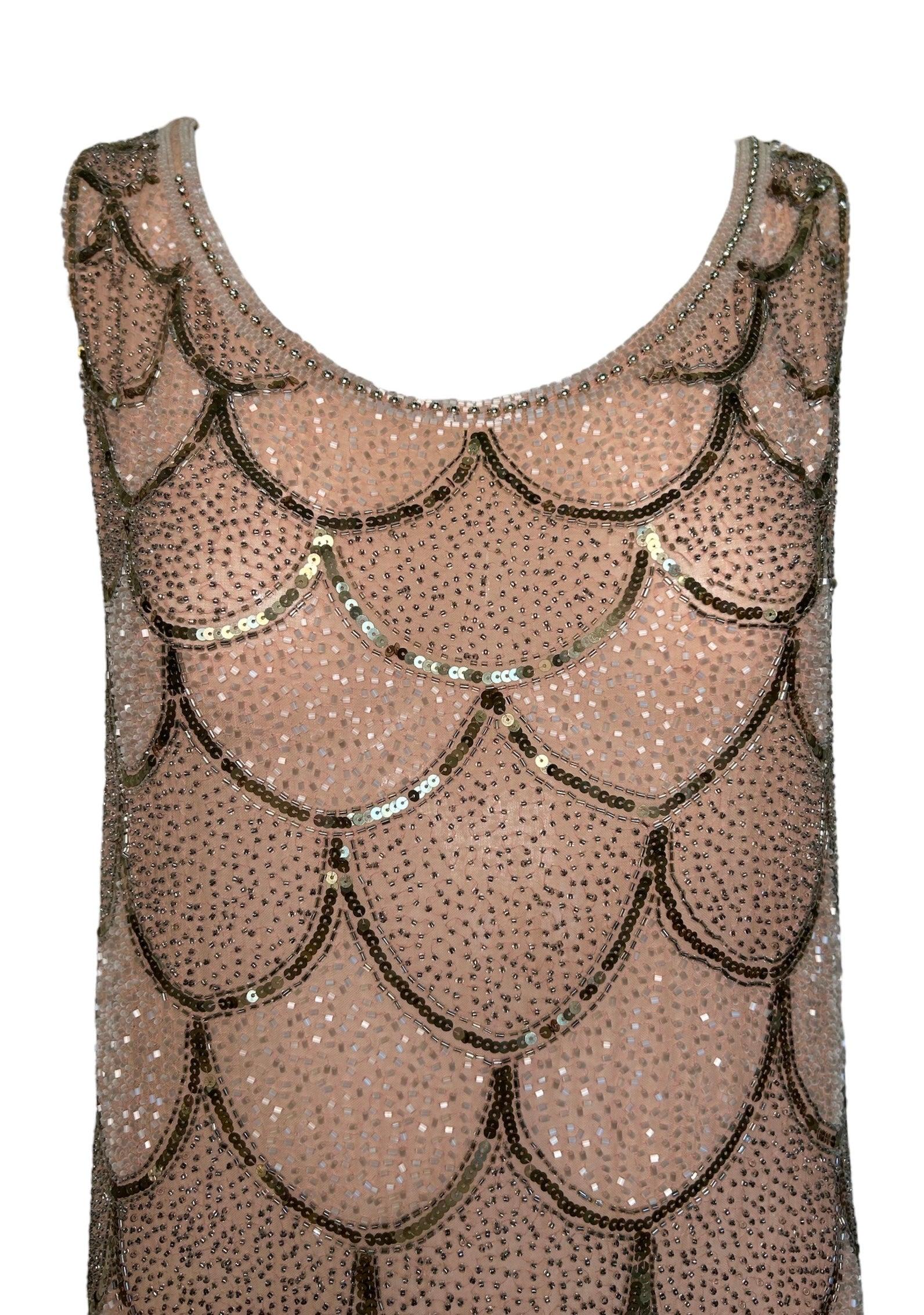 This is the epitome of 1920s elegance. Immaculately beaded on cotton with a scallop bodice with a drop waist pattern switch, equally as beautiful and intricate! Glittering sequins and delicate baby pink hues create a glamorous cascade of shimmering