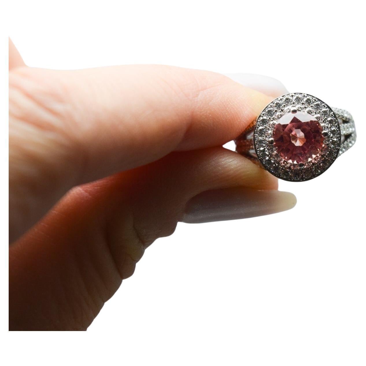 Questo anello è davvero stupendo! È delicata ed elegante da un lato e regale e lussuosa dall'altro. Questo anello scintilla con 1,50 carati di diamanti e un delicato scintillio dello zaffiro centrale color pesca. Realizzato in oro bianco 18KT nella