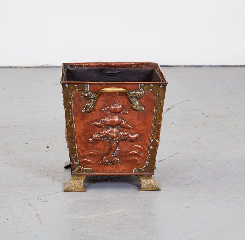 Good English Arts & Crafts period hammered copper and brass kindling bin, the sides decorated with peacock in a landscape on two sides and majestic cypress trees on the other two. Featuring brass hardware and bracket feet, hand riveted construction