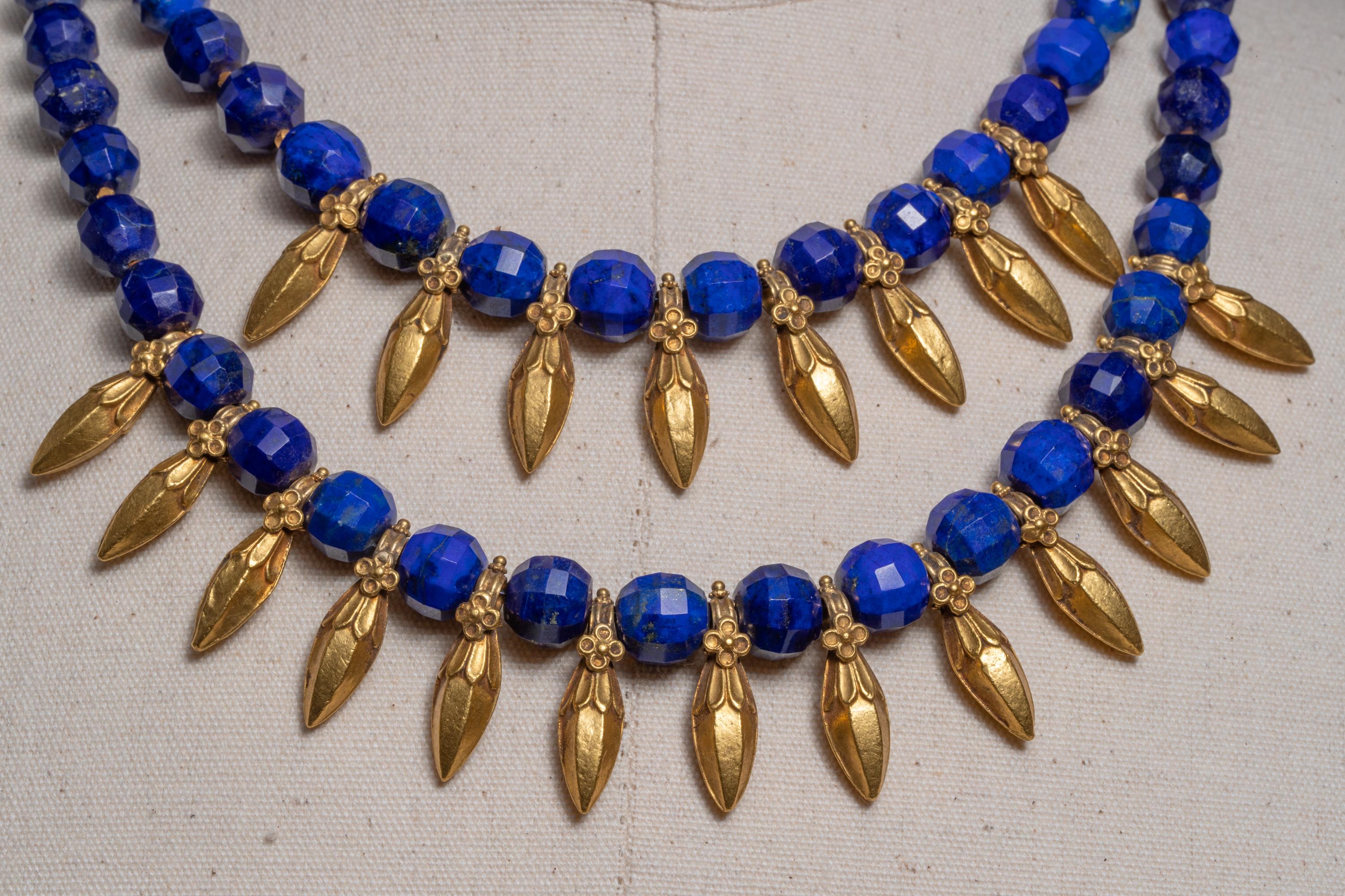 A double-line of old 22K gold spear-shaped pendants with fine detailing paired with exquisite peacock blue lapis lazuli.  Adding to the uniqueness, these lapis beads are faceted and the gold pendants have beautiful detailing.  The length of the