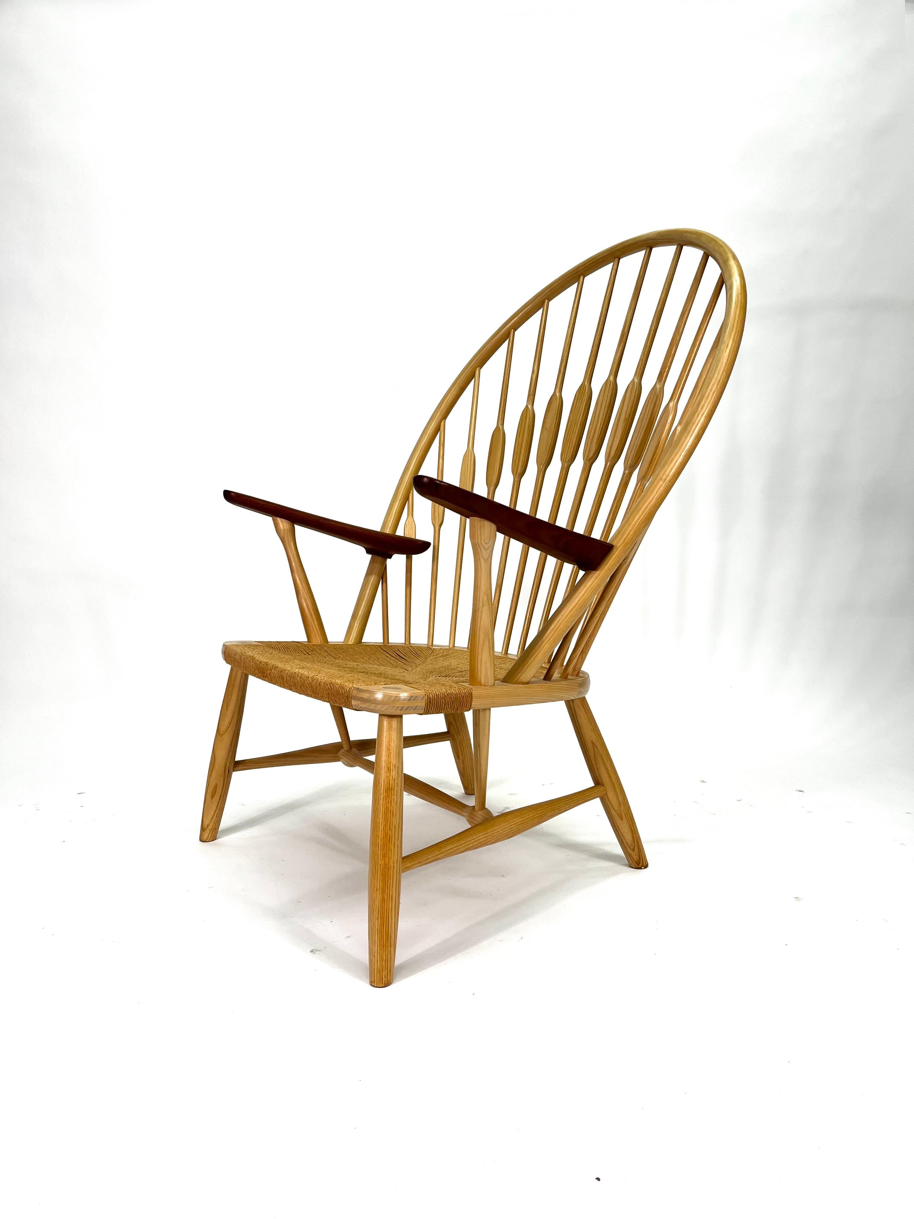 Peacock Chair designed by Hans J. Wegner for PP Møbler is an easy chair with a natural papercord seat. The Peacock Chair is historically anchored in the classic British Windsor Chair. As were the case with many of his early works, Wegner updated his
