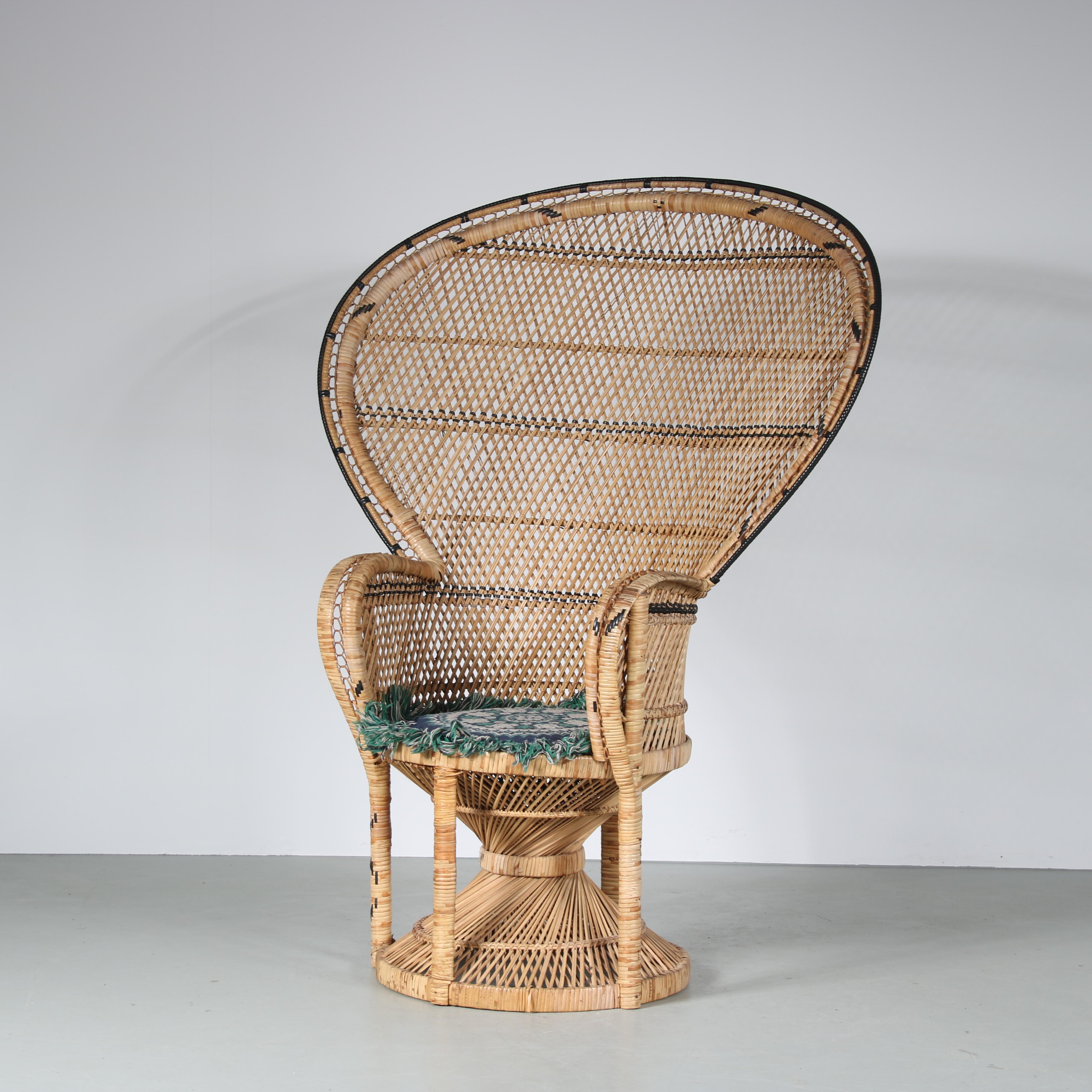 An eye-catching large “Peacock” easy chair by Kok Maisonette from France around 1960.

This impressive and highly recognizable piece is made of natural rattan in nice curved shapes. The tall, round and decorative backrest gives this piece an
