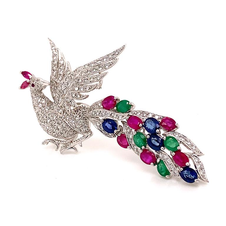 Gorgeous Peacock Diamond Ruby Sapphire & Emerald Brooch in 18k White Gold. This magnificent peacock is crafted in 18k white gold. The body and tail are pave set with 139 total round brilliant cut diamonds. The tail has 39 diamonds and the rest of
