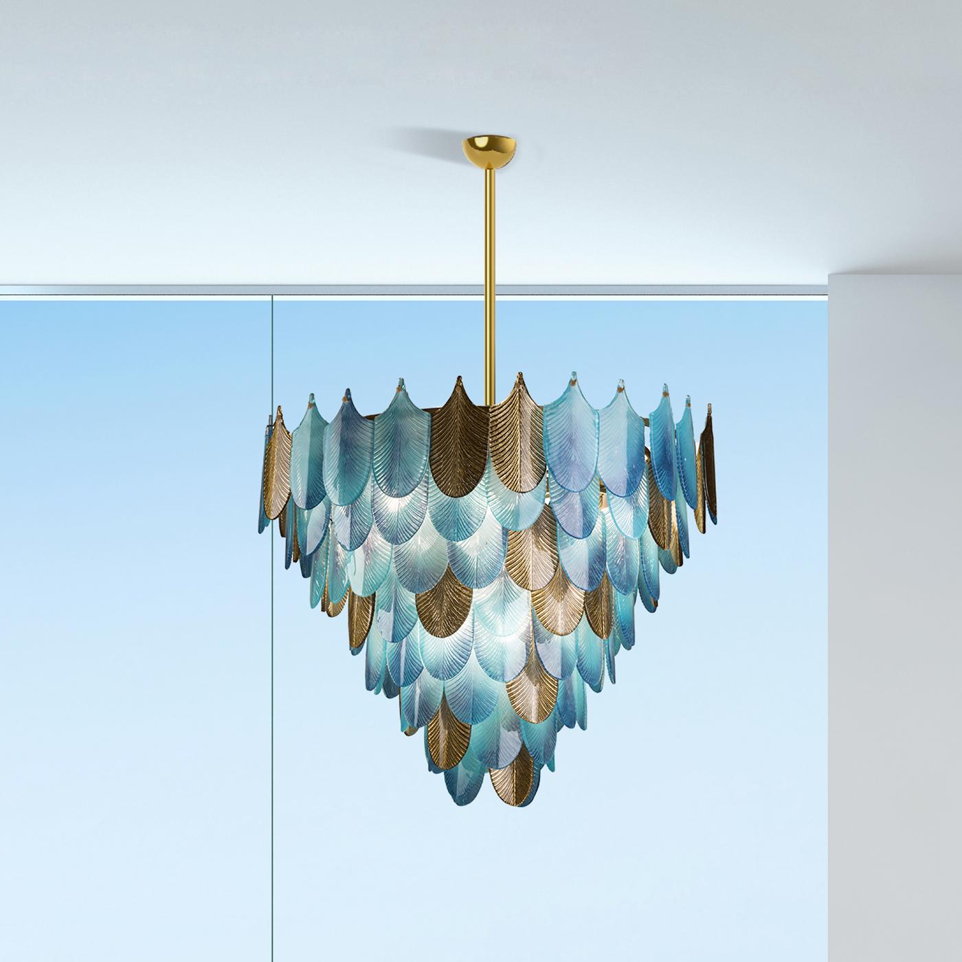 This chandelier is a work of functional art and a superb sculptural accent for a refined home, part of the Home Couture collection. Its structure in brass supports a myriad of elements evoking the silhouette and texture of peacock feathers and made