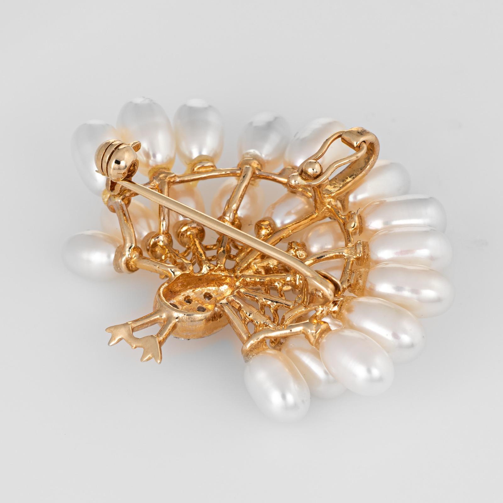 Finely detailed peacock pendant/brooch crafted in 14 karat yellow gold.  

Diamonds total an estimated 0.05 carats (estimated at H-I color and SI1-2 clarity). The freshwater pearls range in size from 6.5mm x 4mm to 7.5mm x 4.5mm.

The elaborate