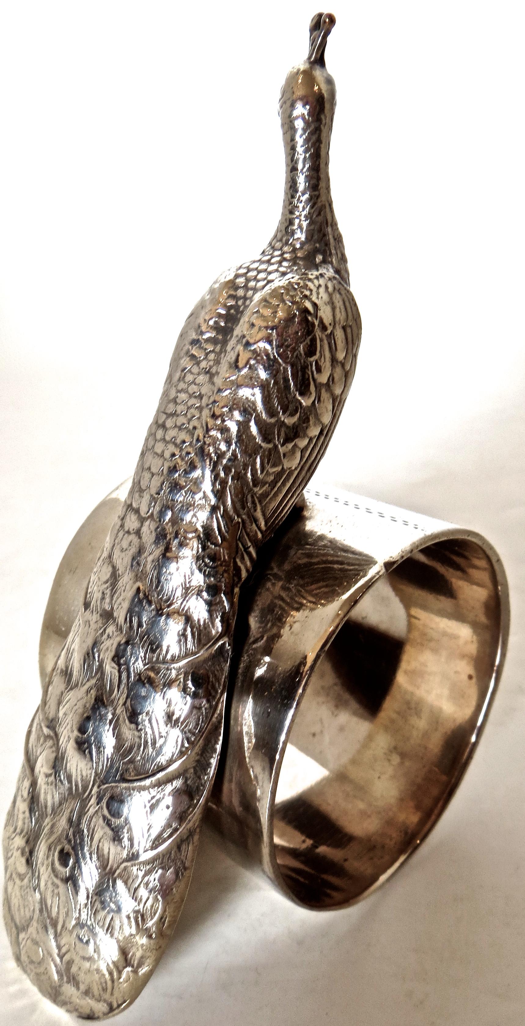 Birds of all types were a common theme for Victorian silver plated napkin rings. Of American manufacture, this particular ring depicts a highly detailed peacock with broad flowing feathers sitting atop a circular ring. In relief and etched to the
