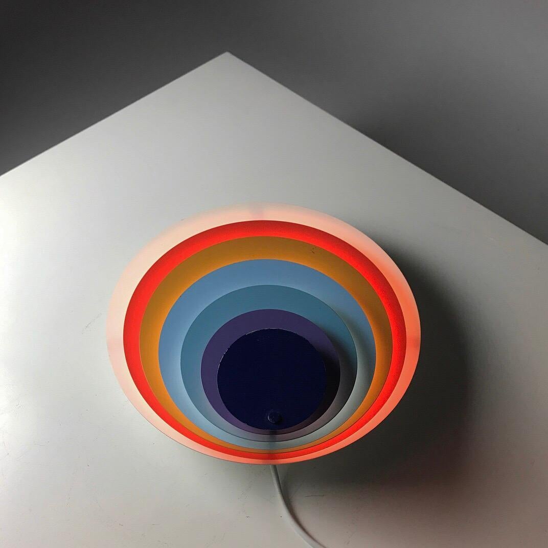 Beautiful Classic Danish 1970s iconic wall light by Bent Karlby for Lyfa, Denmark, 1974.

Peacock is the name of this rare and stunning piece of Danish design from the modern era.

Like the name indicates the light is multicolored with six