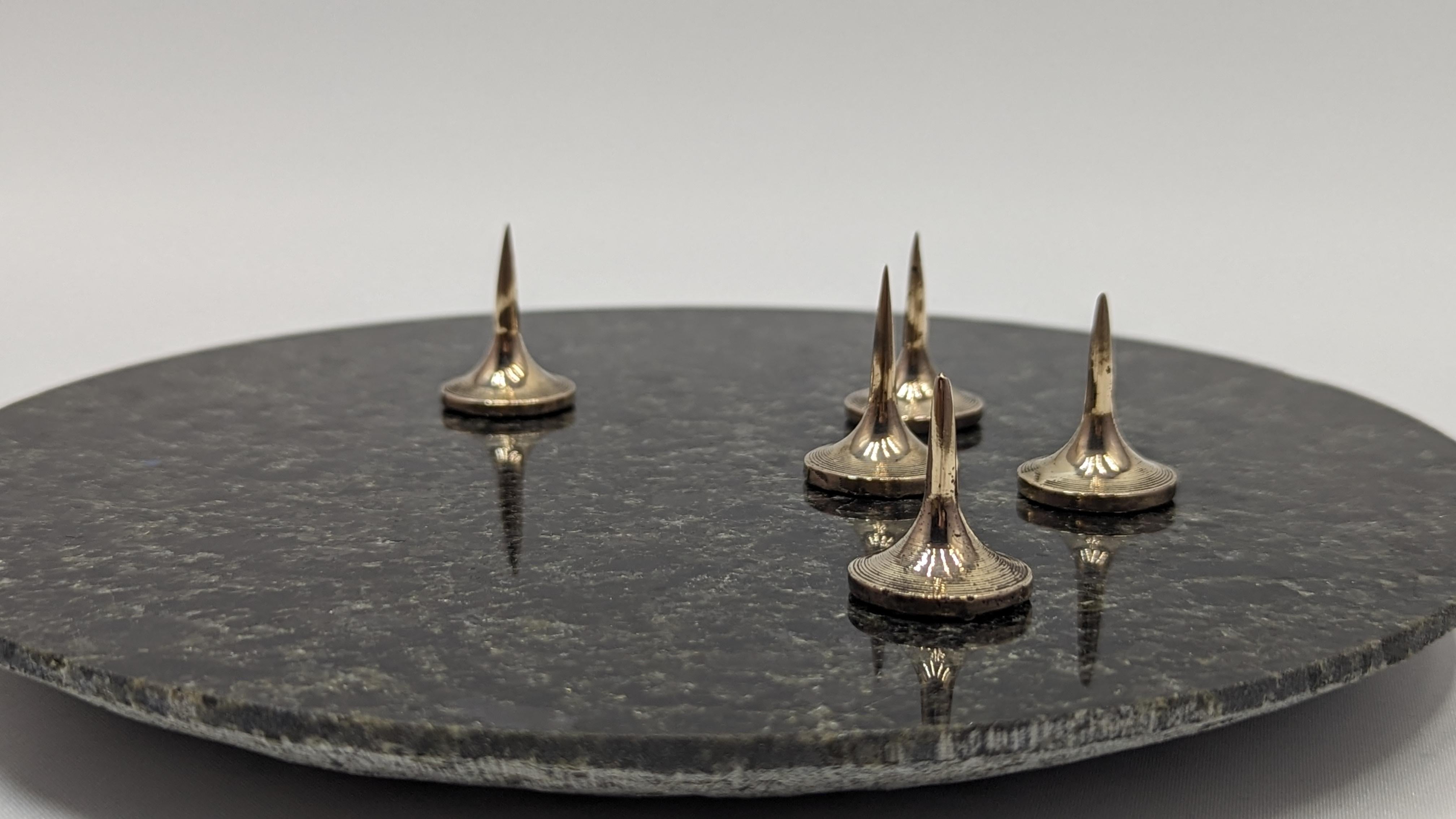 PEAKS
Candelabra with mobile bronze candle spikes. Each candle spikes can be removed such way you can variate the amont of candles (up to 5) on the granite tray.
The support is made out of a green-grey granite from Portugual. 

The bronze work