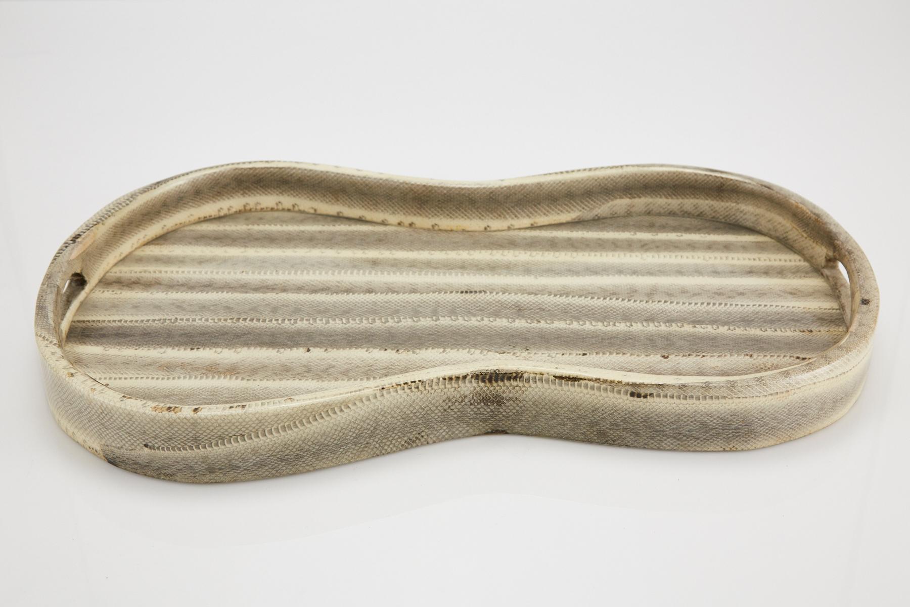 Large peanut-shaped serving or dressing tray executed in snakeskin over wood body. Clear coat finish protects snakeskin from wear. Underside is painted wood. Perfect for your dressing table or breakfast in bed.