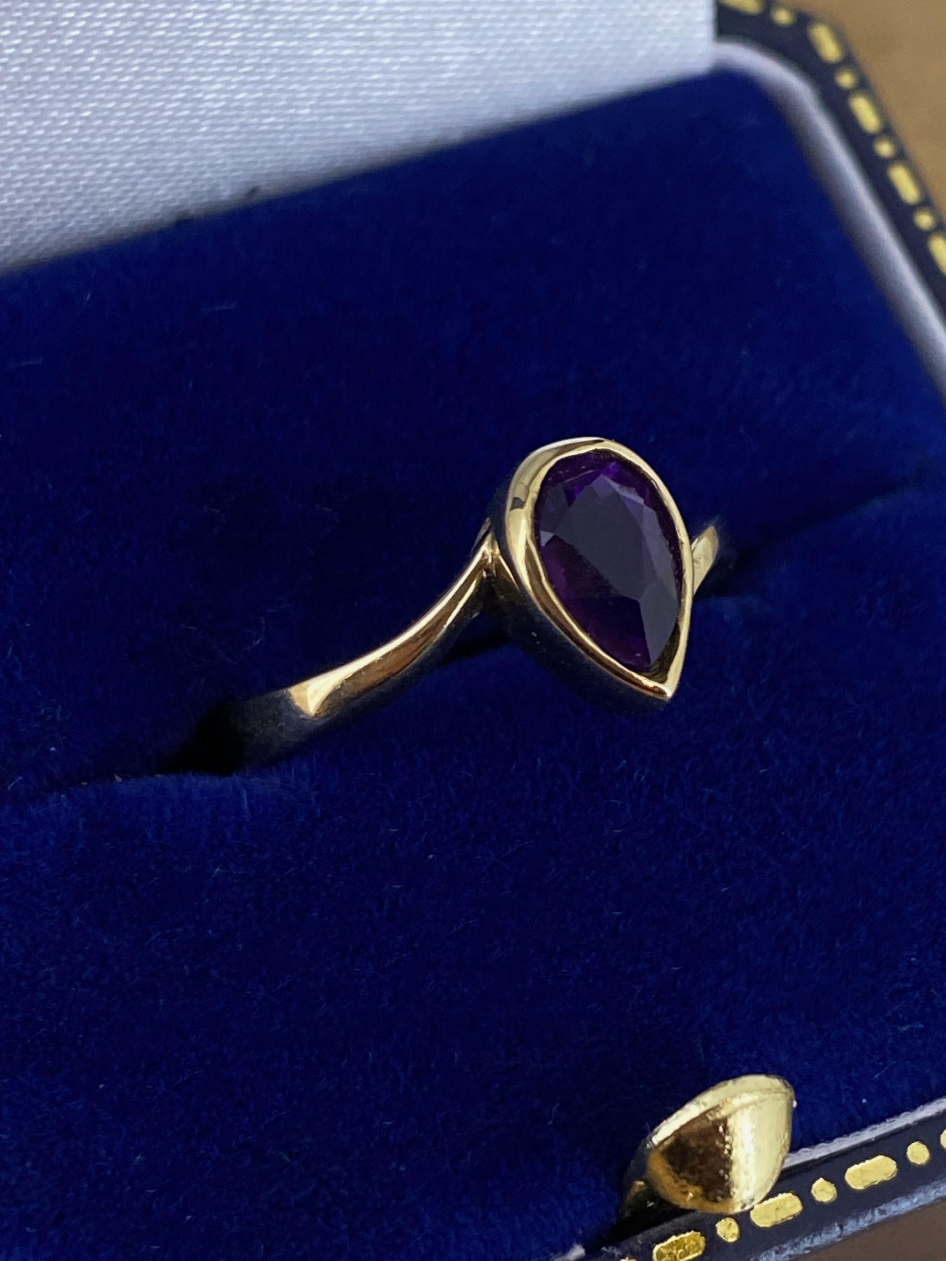 Réalisé en or jaune 9K, 
L'anneau est centré sur une améthyste en forme de poire (Teardrop). 
de 0,60ct environ (7,5mm x 5mm)
d'un violet vif et profond
lunette 

Épaulement solide ByPass de 2 mm
tige de 3 mm (estampillée 375)

Poids total de