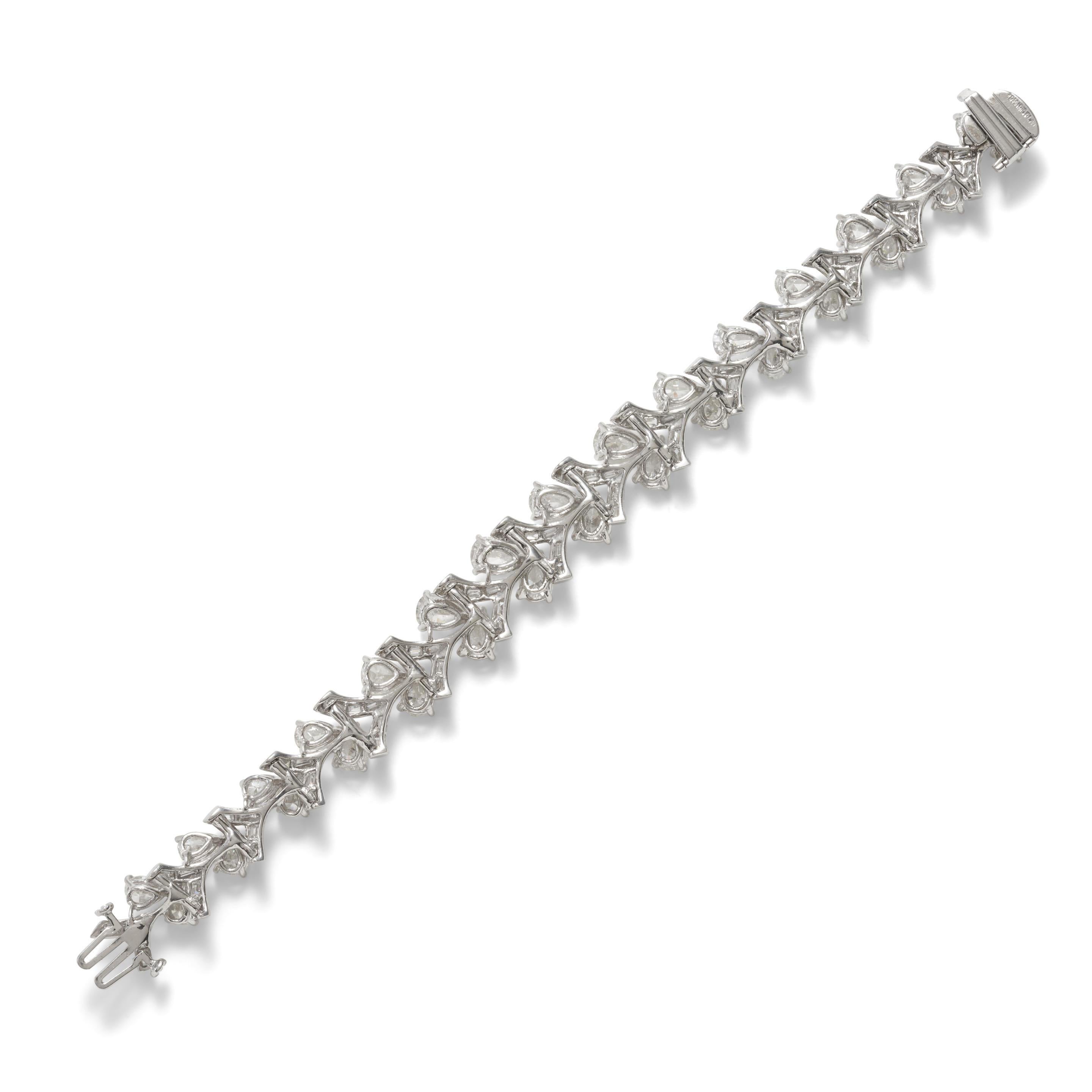 This magnificent bracelet is set with pear and baguette-cut diamonds, weighing approximately 15.00 carats, mounted in platinum, designed to resemble stems of roses.
