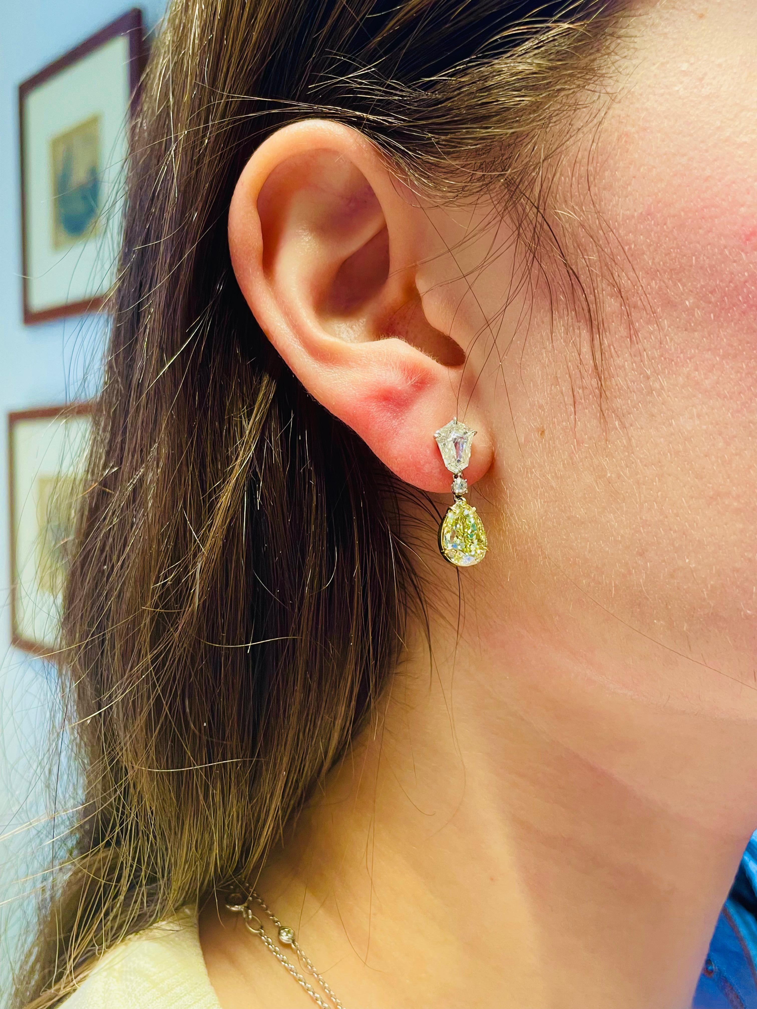 Sophisticated and classic, these yellow diamond drop earrings add a gorgeous pop of sparkle and color. Two beautifully matched fancy light yellow pear shape diamonds (5.44 carats total) dangle from two white kite diamonds (totaling 1.59 carats) and