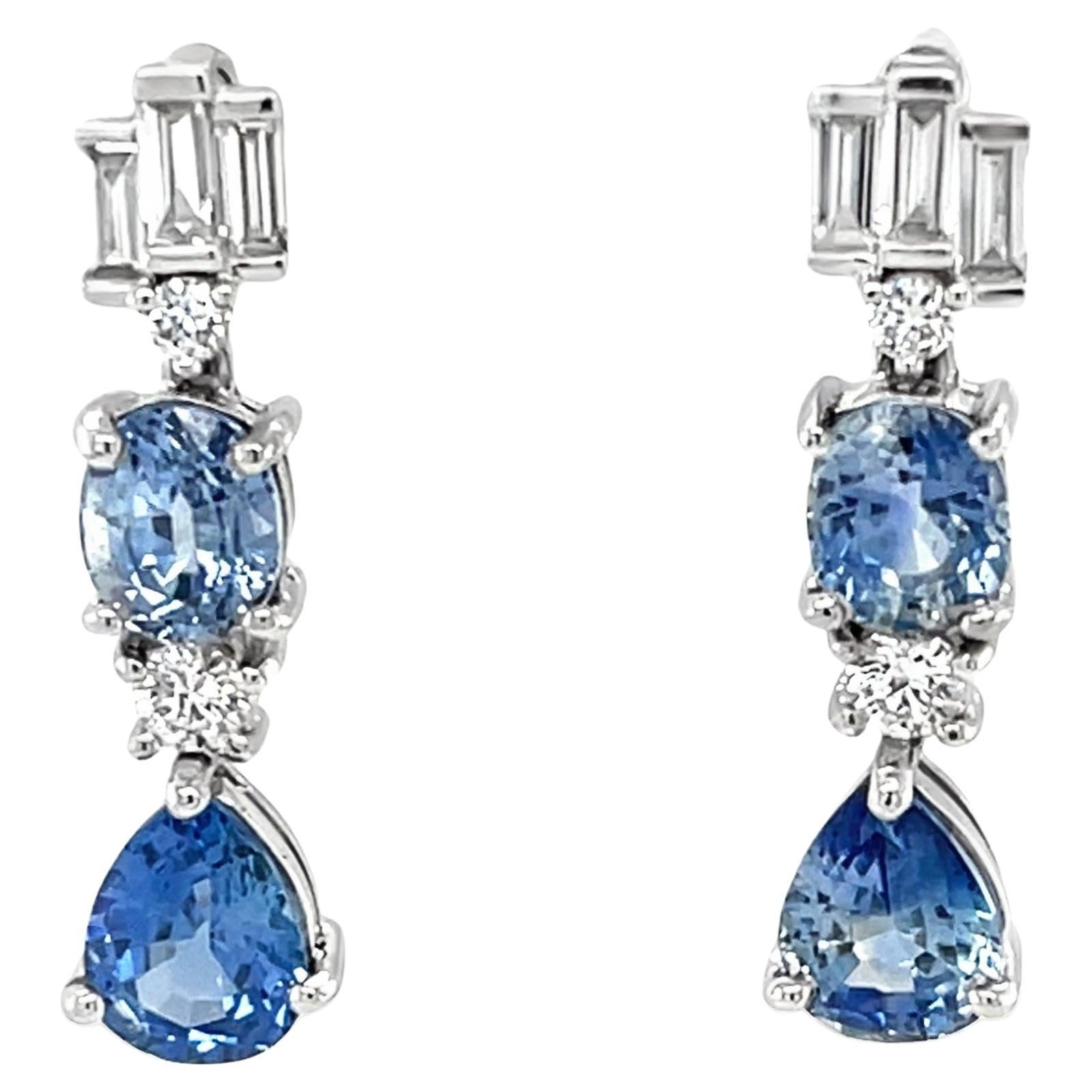 Questi splendidi orecchini sono caratterizzati da splendidi zaffiri blu in due forme diverse e splendide sfumature, incastonati con diamanti scintillanti in oro bianco 18 carati. Le pere di zaffiro blu brillante sono accentate da diamanti rotondi