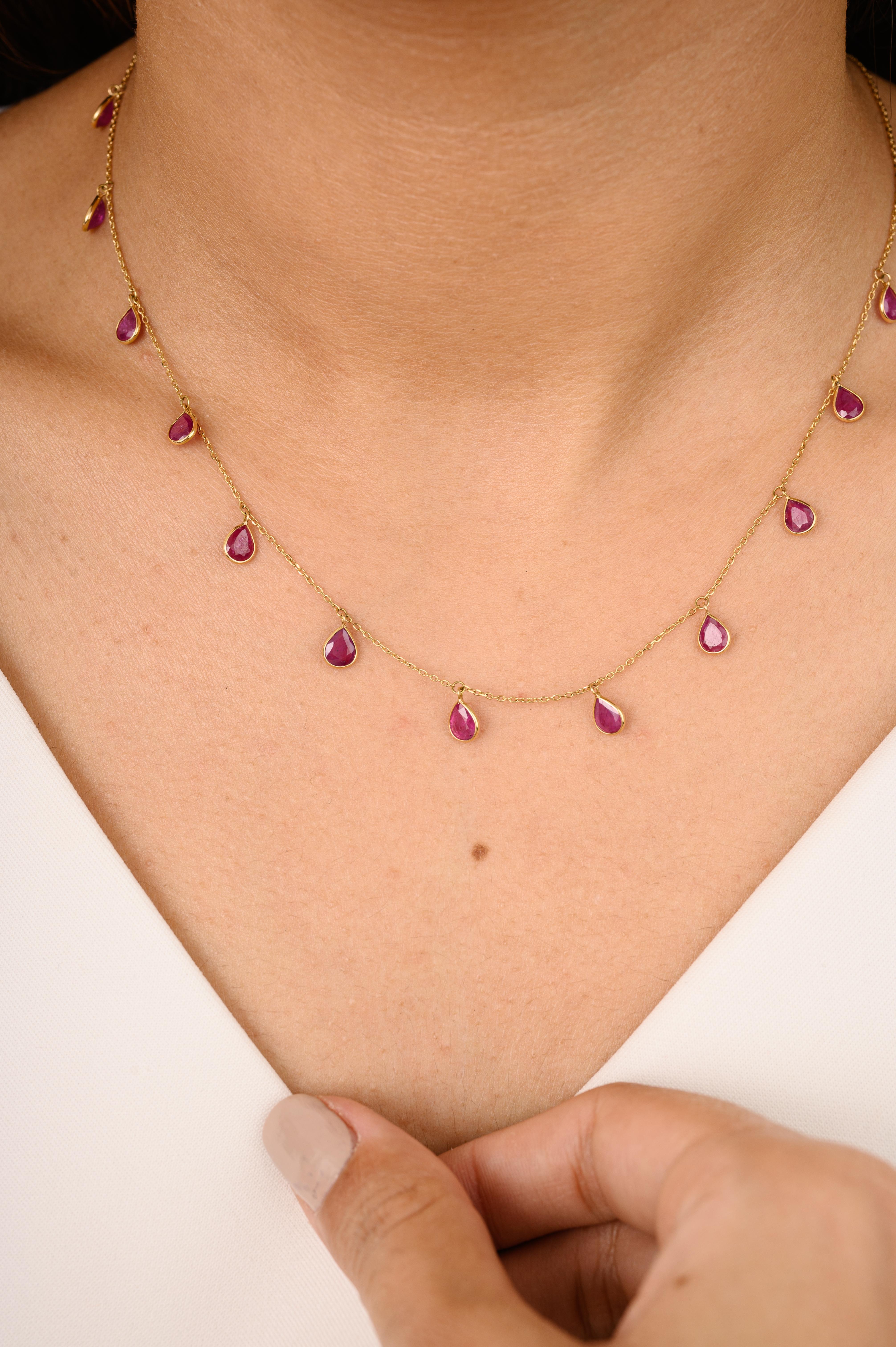 Pear Bezel Set Ruby Fringe Necklace in 18K Gold studded with pear cut ruby. This stunning piece of jewelry instantly elevates a casual look or dressy outfit. 
Ruby improves mental strength.
Designed with a pear cut ruby set in bezel settings