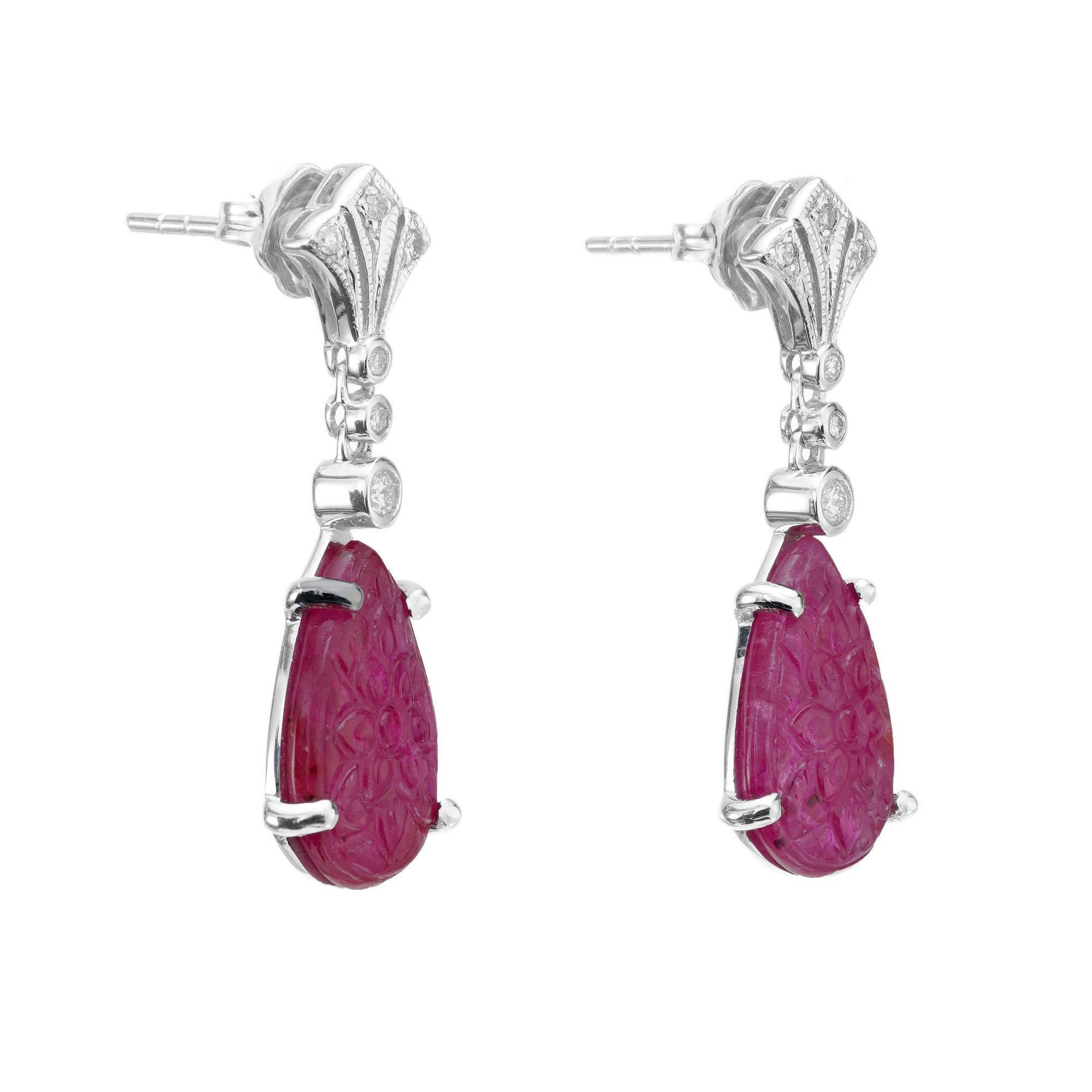 1940's Carved translucent Ruby and diamond dangle earrings. Two pear shaped rubies with 12 round cut accent diamonds in 18k white gold settings. 

2 carved pear Rubies, 13.42 x 7.43mm
2 round diamonds, approx. total weight .04cts, H, SI1
10 round