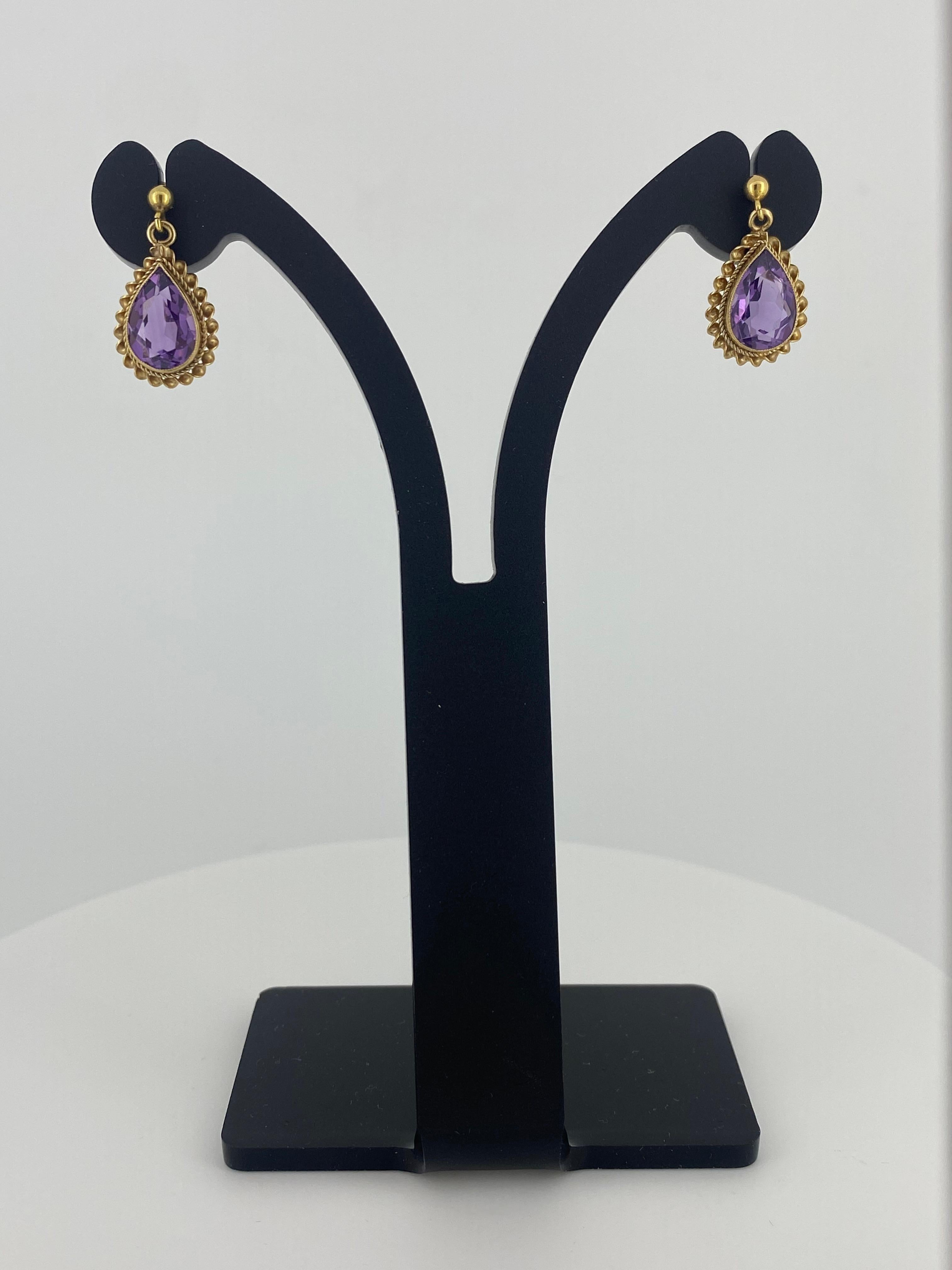These Retro Handmade Drop Pendant Earrings
each feature Natural Amethyst 
of Royal Purple Colour, 
of impressive 2.50ct approx. (11mm x 8mm)
of desirable teardrop shape / pear cut 

In rubbed over setting, 
within an elaborate twisted rope border,